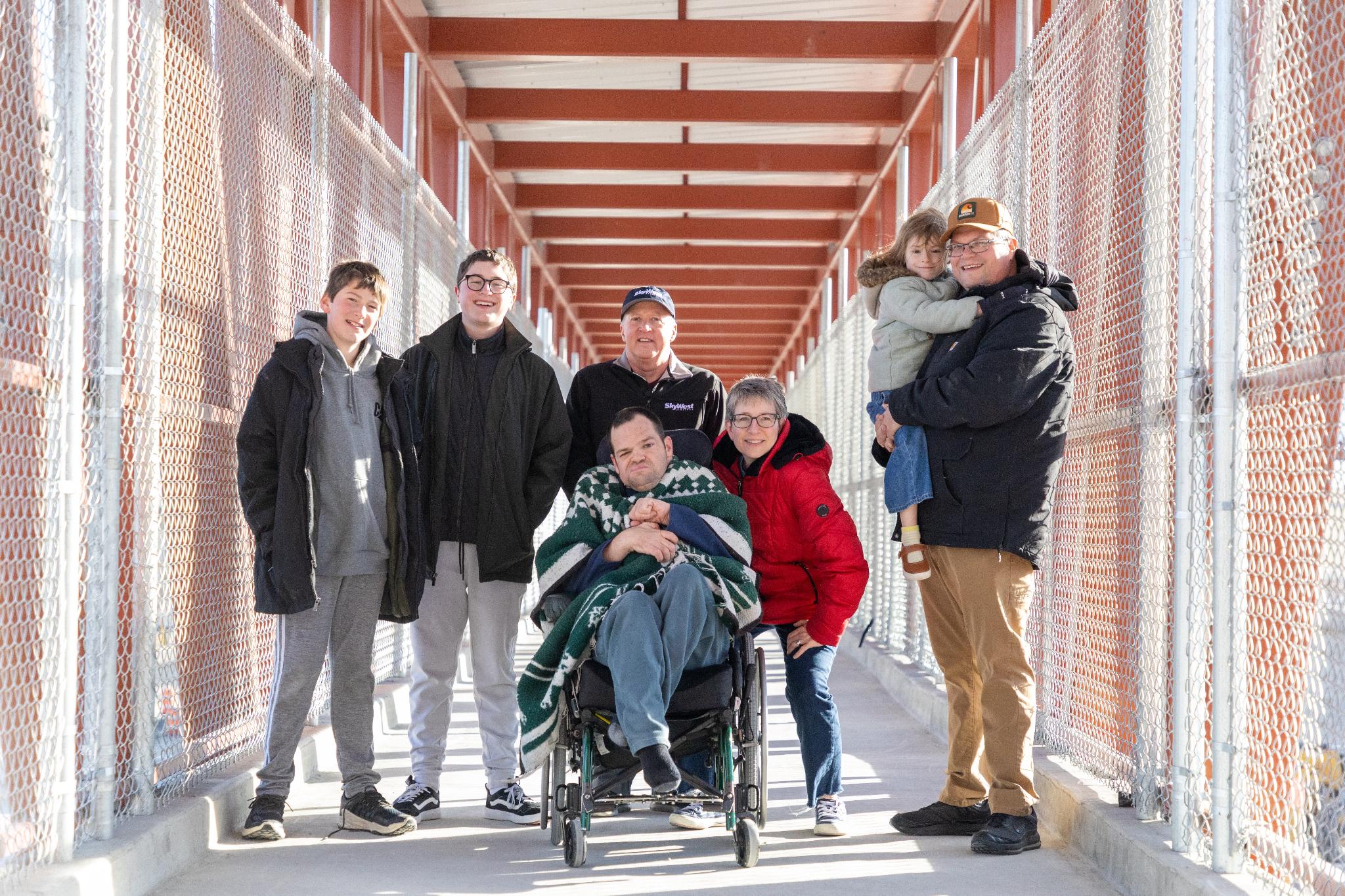 The Clarks and Chesleys pose after crossing the new pedestrian bridge over Bangerter Highway near 9800 South in South Jordan on Saturday.