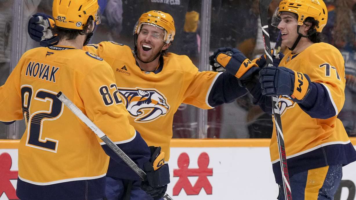 Nashville Predators Jonathan Marchessault, center, celebrates his goal with teammates Tommy Novak (82) and Luke Evangelista (77) during the second period of an NHL hockey game against the Carolina Hurricanes, Monday, Dec. 23, 2024, in Nashville, Tenn.