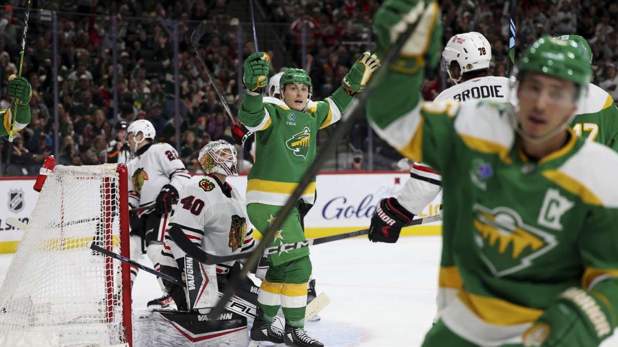 Minnesota Wild defenseman Jared Spurgeon, foreground right, and center Ben Jones, center, celebrate after Spurgeon's goal while Chicago Blackhawks goaltender Arvid Soderblom (40) reacts during the second period of an NHL hockey game, Monday, Dec. 23, 2024, in St. Paul, Minn.