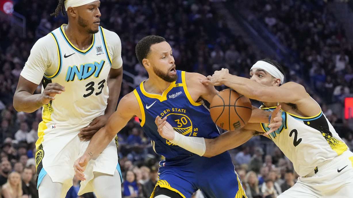 Golden State Warriors guard Stephen Curry (30) reaches for the ball between Indiana Pacers center Myles Turner (33) and guard Andrew Nembhard (2) during the first half of an NBA basketball game in San Francisco, Monday, Dec. 23, 2024.