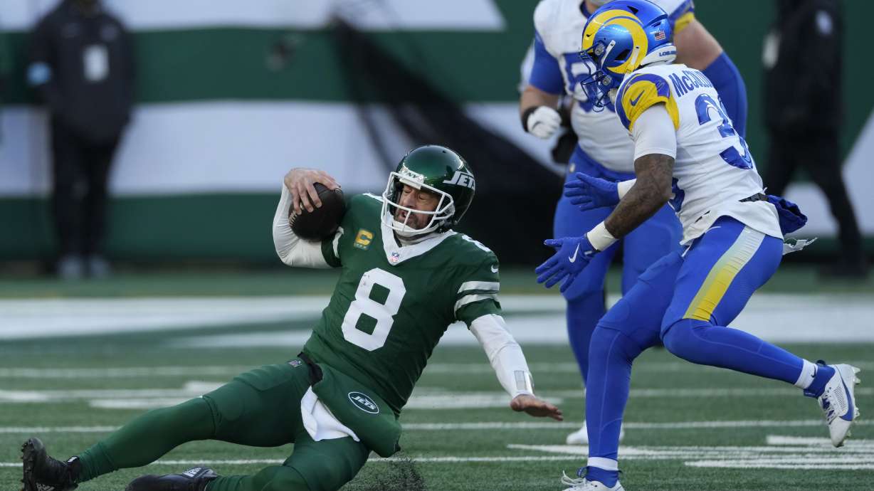 New York Jets quarterback Aaron Rodgers (8) slides in front of Los Angeles Rams safety Jaylen McCollough during the second half of an NFL football game in East Rutherford, N.J., Sunday, Dec. 22, 2024.