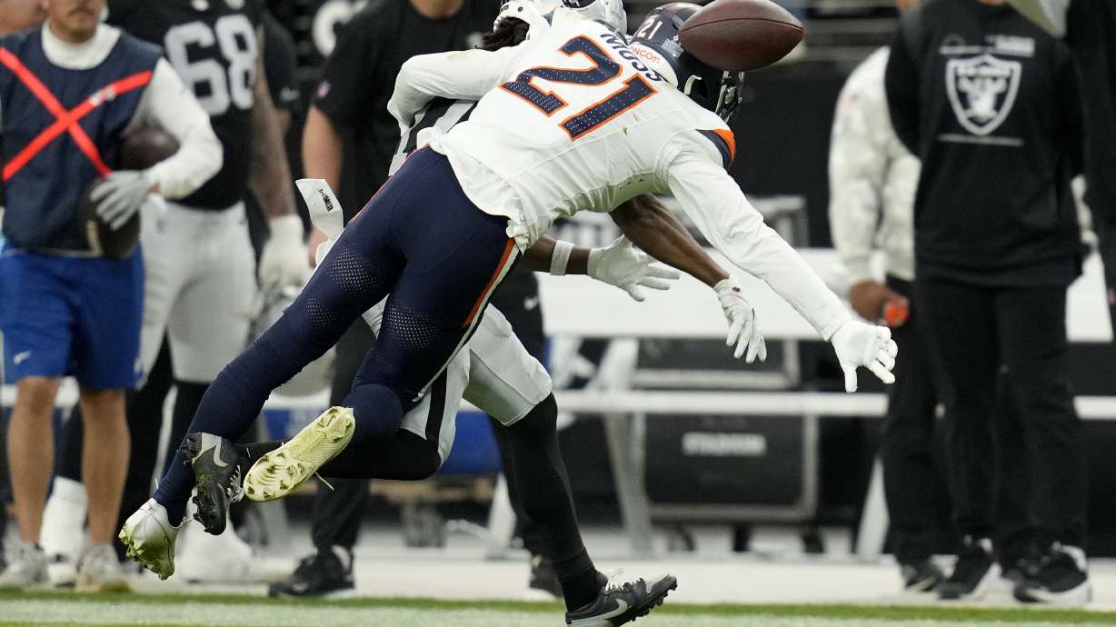 Denver Broncos cornerback Riley Moss (21) knocks down a pass intended for Las Vegas Raiders wide receiver Tre Tucker (11) during the first half of an NFL football game, Sunday, Nov. 24, 2024, in Las Vegas.