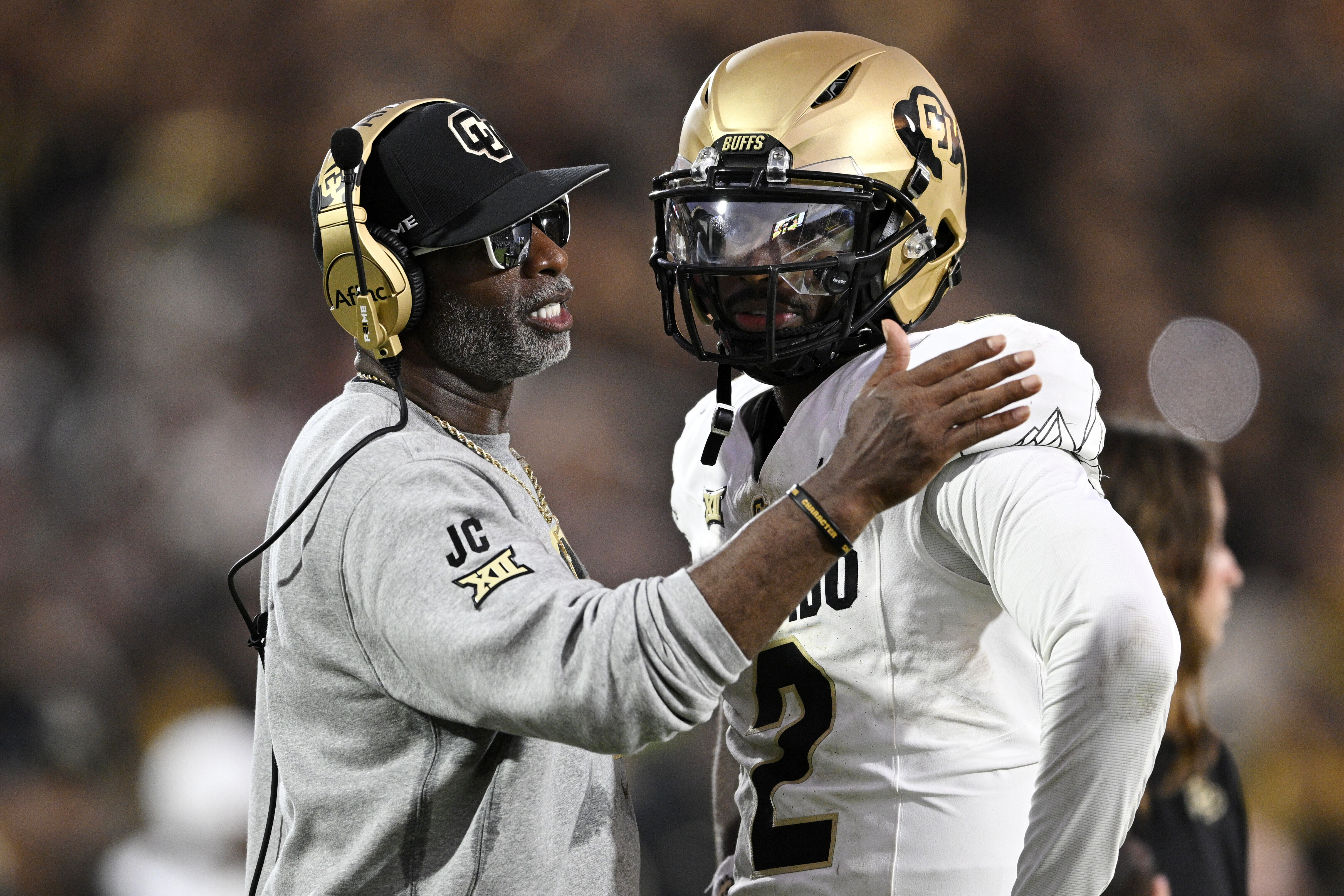 FILE - Colorado head coach Deion Sanders, left, talks with quarterback Shedeur Sanders (2) during a timeout in the second half of an NCAA college football game against Central Florida, Saturday, Sept. 28, 2024, in Orlando, Fla.
