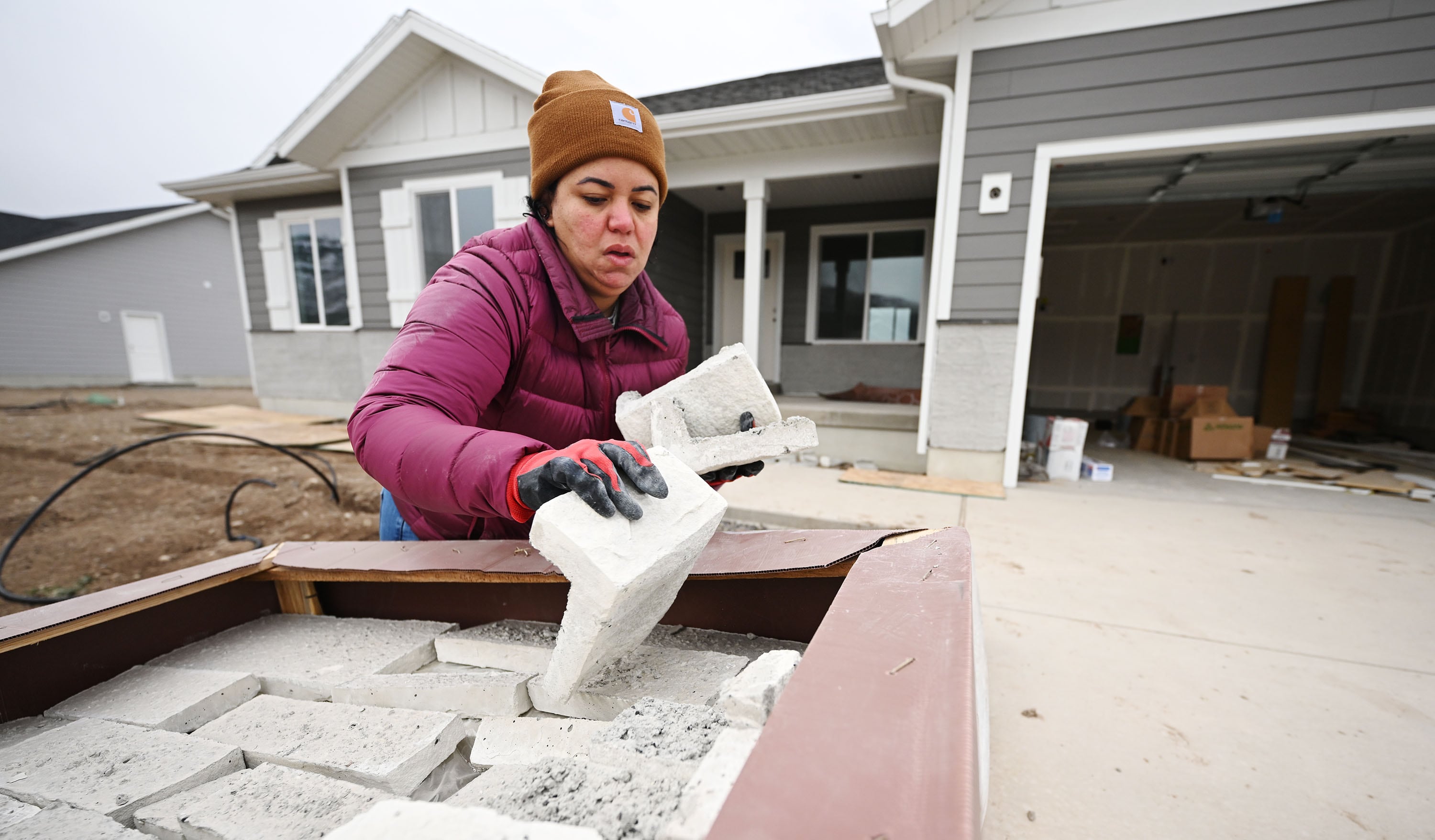 Nanilia Lara pulls stone from a crate as she lays out designs as homebuyers take part in Self-Help Homes, which completes affordable housing projects by facilitating loans and providing training so people can build their own houses, in Salem on Dec. 14.