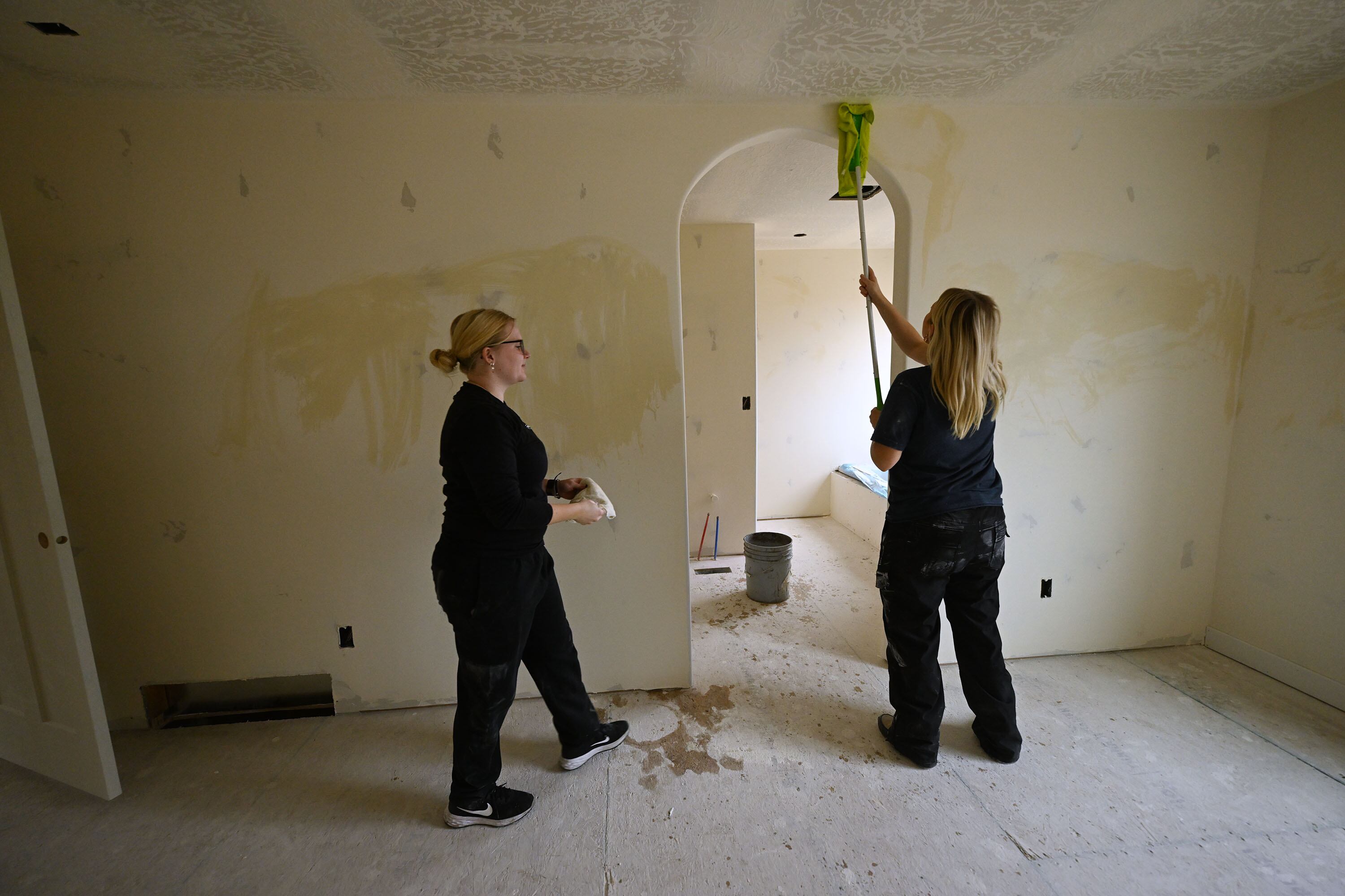 Kady Barnes and Bella Rich work to wipe down walls as homebuyers take part in Self-Help Homes, which completes affordable housing projects by facilitating loans and providing training so people can build their own houses, in Salem on Dec. 14.