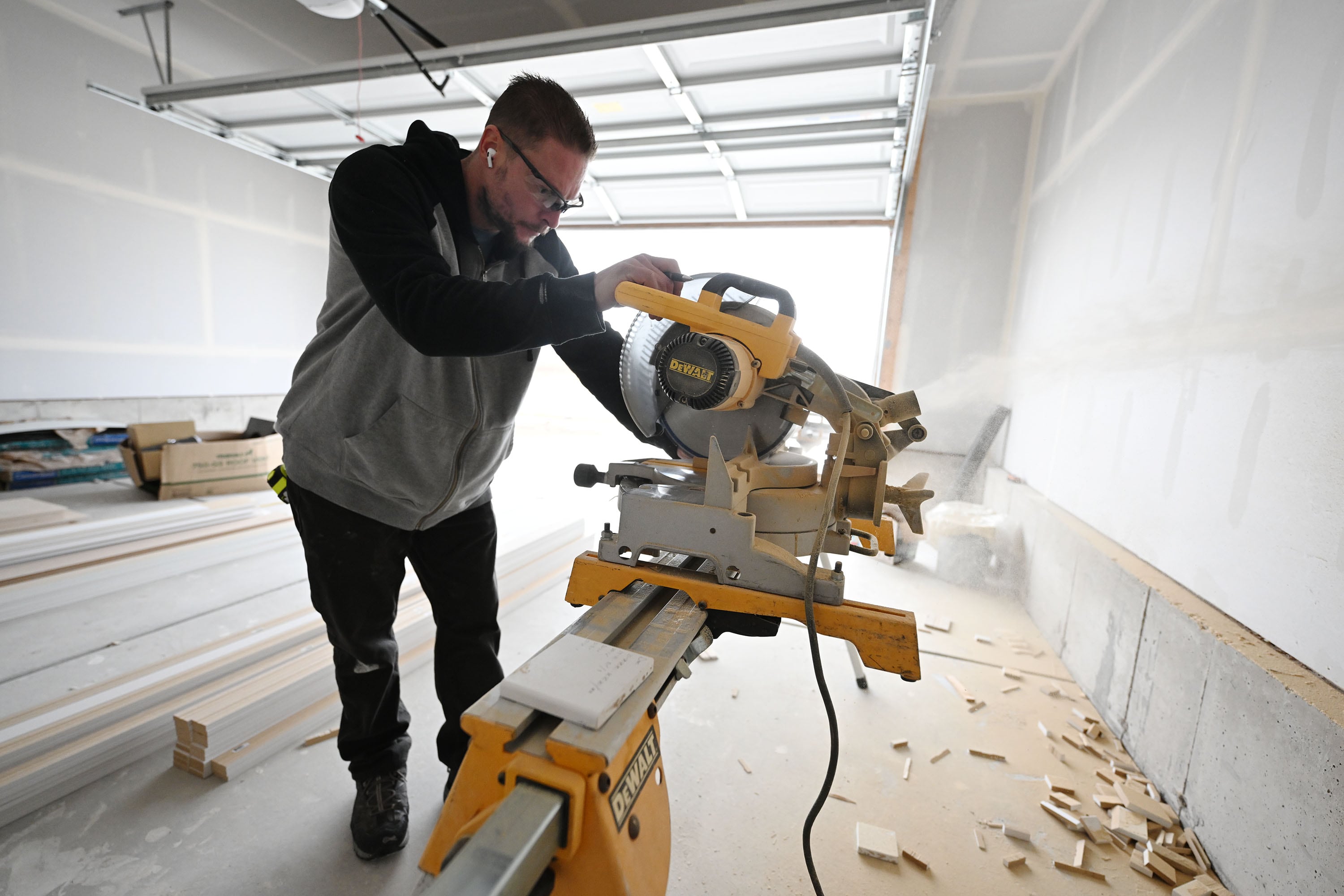 Nolan Kelsch cuts door casing as he and other homebuyers take part in Self-Help Homes, which completes affordable housing projects by facilitating loans and providing training so people can build their own houses, in Salem on Dec. 14.