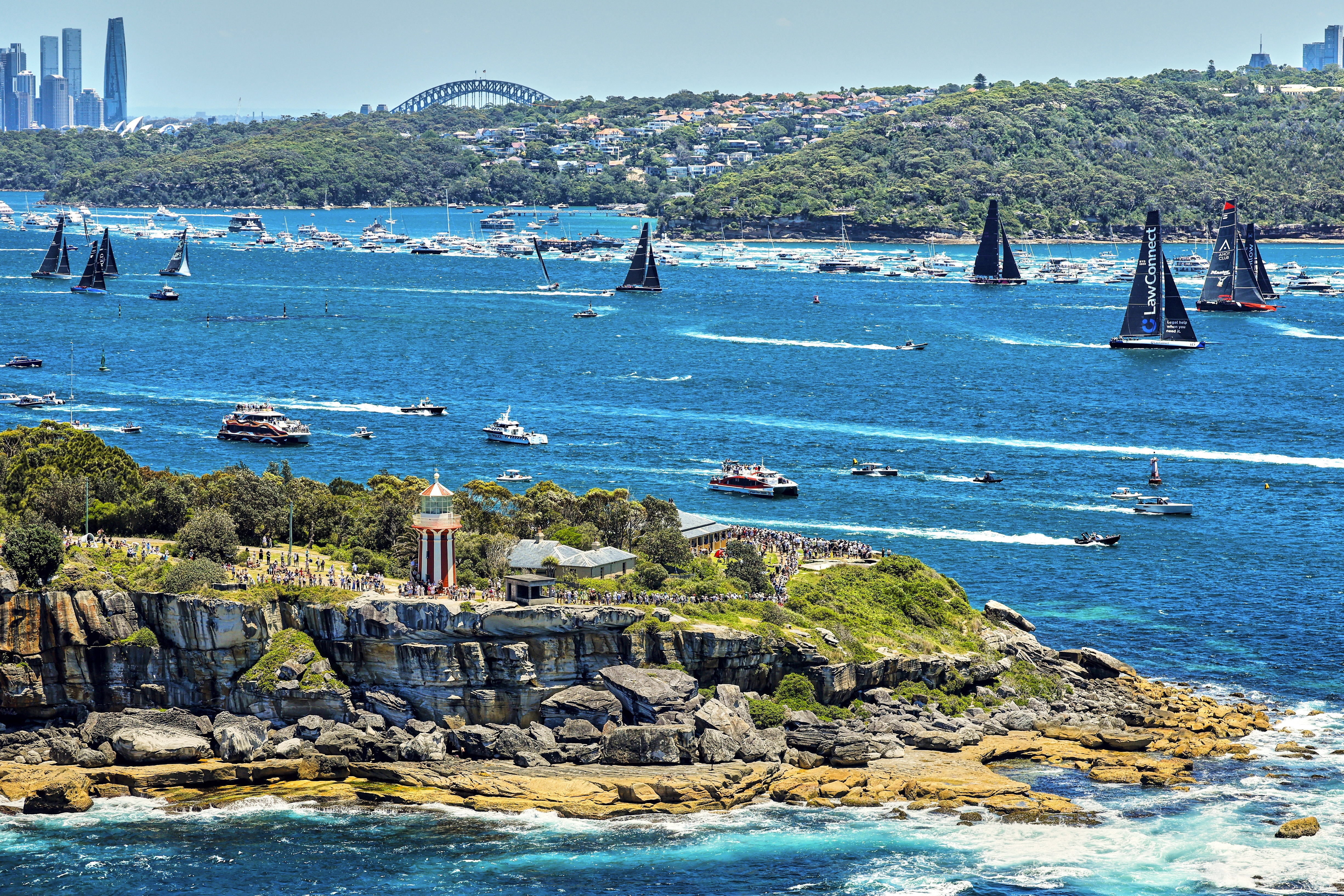 In this photo provided by Rolex, competitors sail towards the heads as they leave Sydney Harbour at the start of the Sydney to Hobart yacht race in Sydney, Thursday, Dec. 26, 2024.