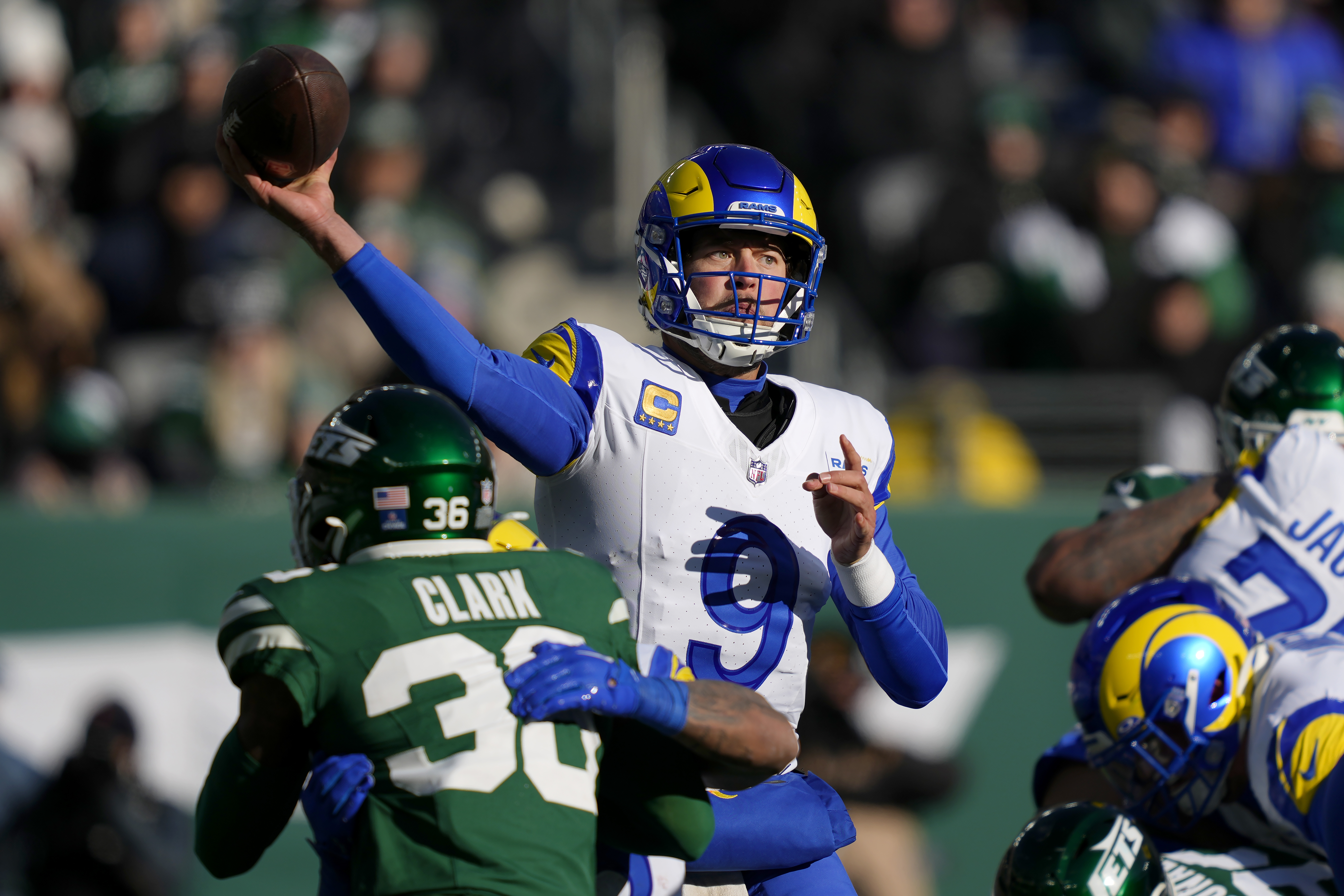 Los Angeles Rams quarterback Matthew Stafford (9) passes as New York Jets safety Chuck Clark, bottom left, applies pressure during the first half of an NFL football game in East Rutherford, N.J., Sunday, Dec. 22, 2024.