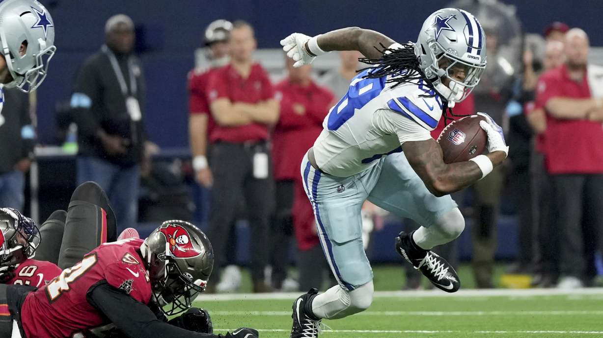 Dallas Cowboys wide receiver CeeDee Lamb (88) breaks a tackle attempt by Tampa Bay Buccaneers linebacker Lavonte David (54) in the first half of an NFL football game in Arlington, Texas, Sunday, Dec. 22, 2024.