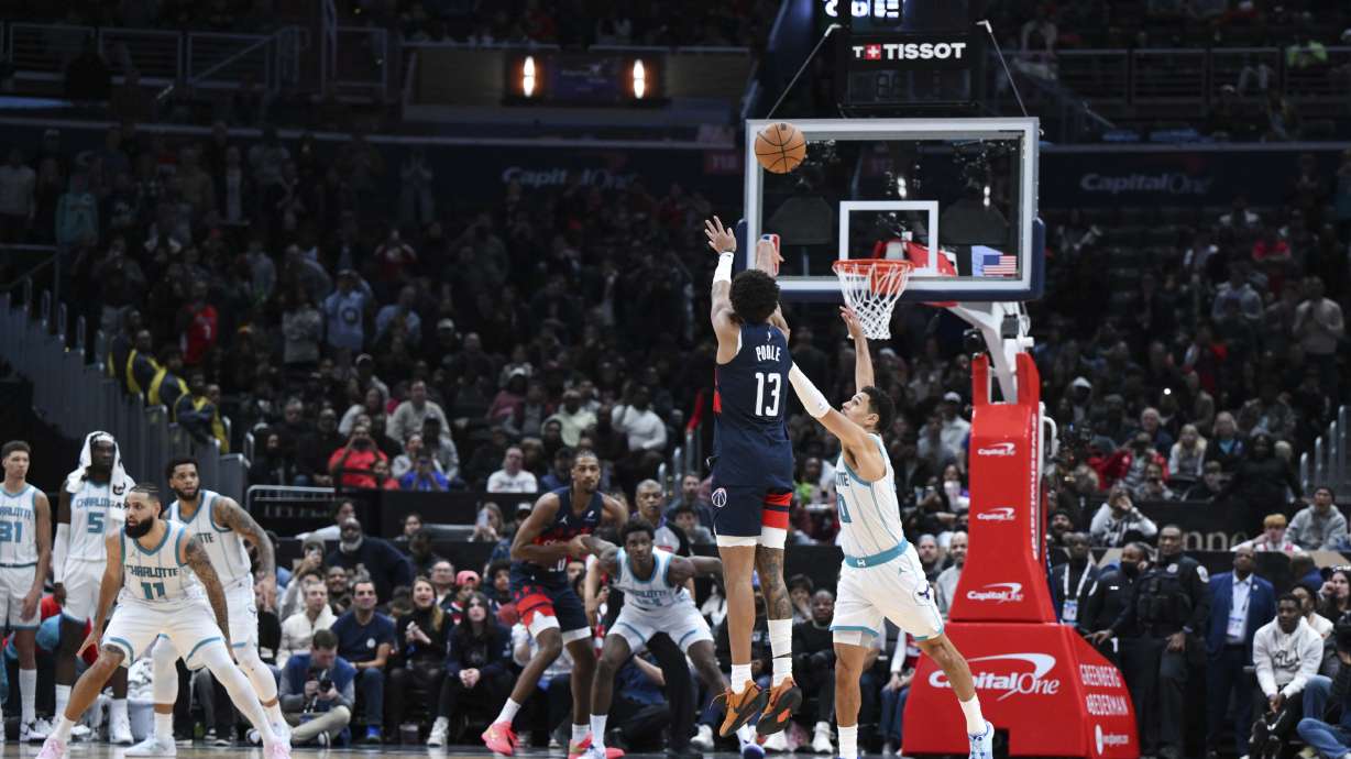 Washington Wizards guard Jordan Poole (13) shoots the winning 3-point basket as Charlotte Hornets guard Josh Green, right, defends during the second half of an NBA basketball game, Thursday, Dec. 26, 2024, in Washington.