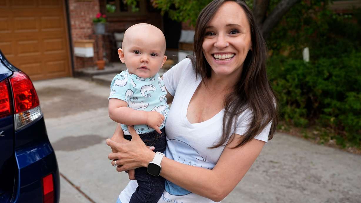 Carrie Martin-Haley holds her son outside their home, May 10, in Greenwood Village, Colorado. Colorado's paid family and medical leave benefits kicked in on Jan. 1, too late for Martin-Haley, a small business owner in Denver who gave birth.