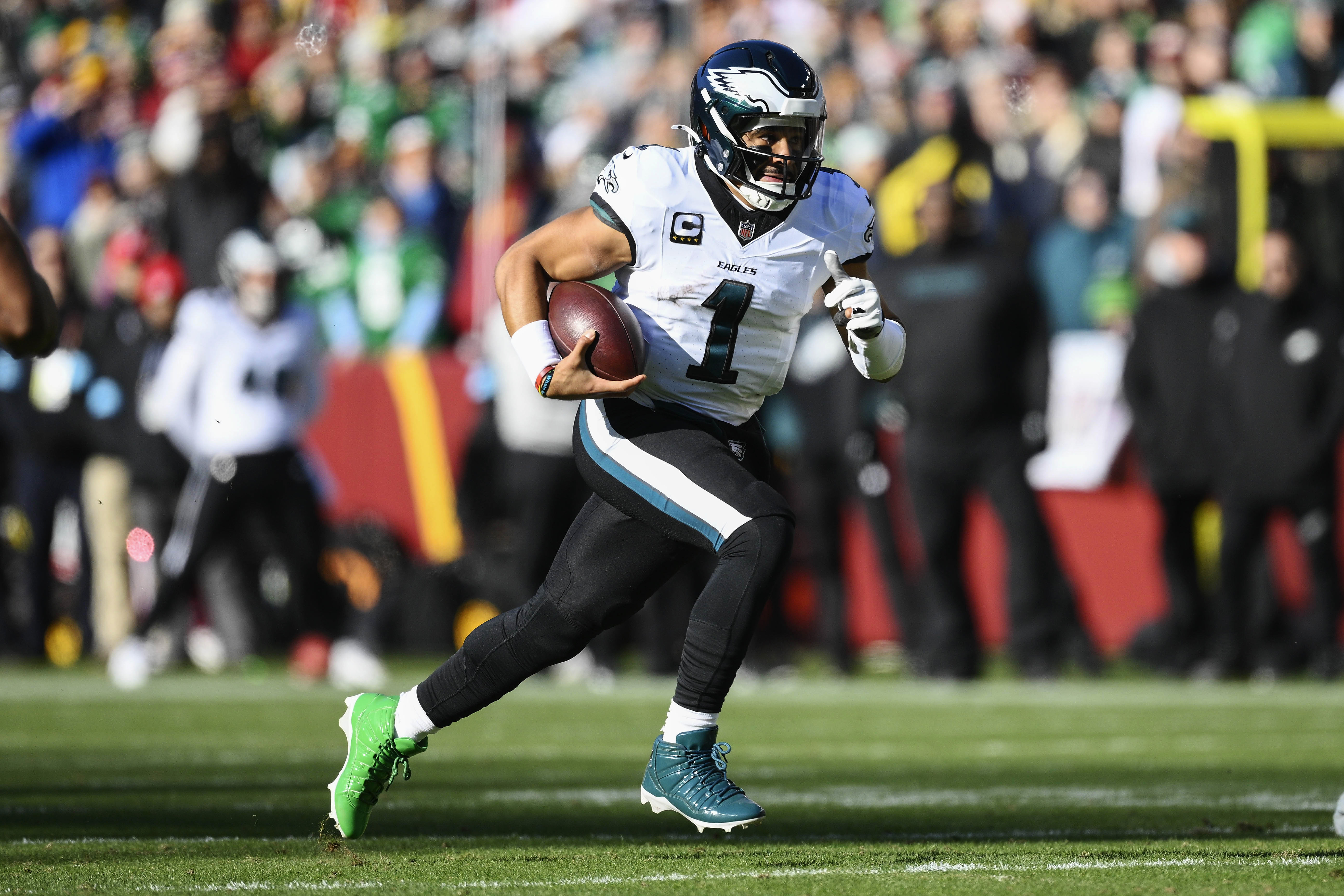 Philadelphia Eagles quarterback Jalen Hurts (1) runs with the ball during the first half of an NFL football game against the Washington Commanders, Sunday, Dec. 22, 2024, in Landover, Md.