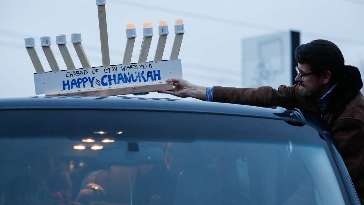 John Sablana affixes a menorah to the roof of his vehicle before a Hanukkah parade through Salt Lake City on Dec. 13, 2020. The event continues each year during the Festival of Lights as an opportunity to highlight Salt Lake City's Jewish community.