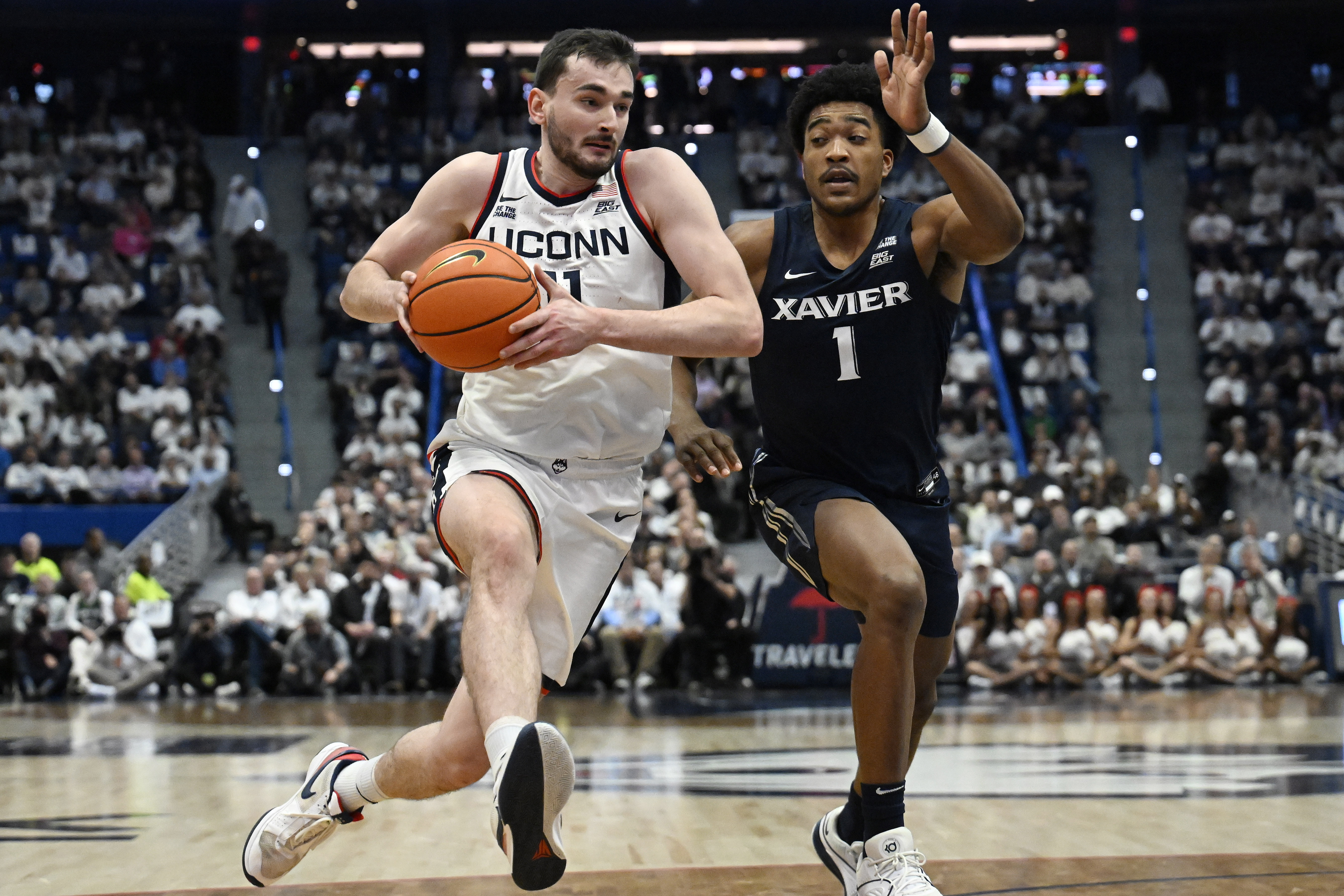 UConn forward Alex Karaban is guarded by Xavier guard Marcus Foster (1) in the first half of an NCAA college basketball game, Wednesday, Dec. 18, 2024, in Hartford, Conn. 
