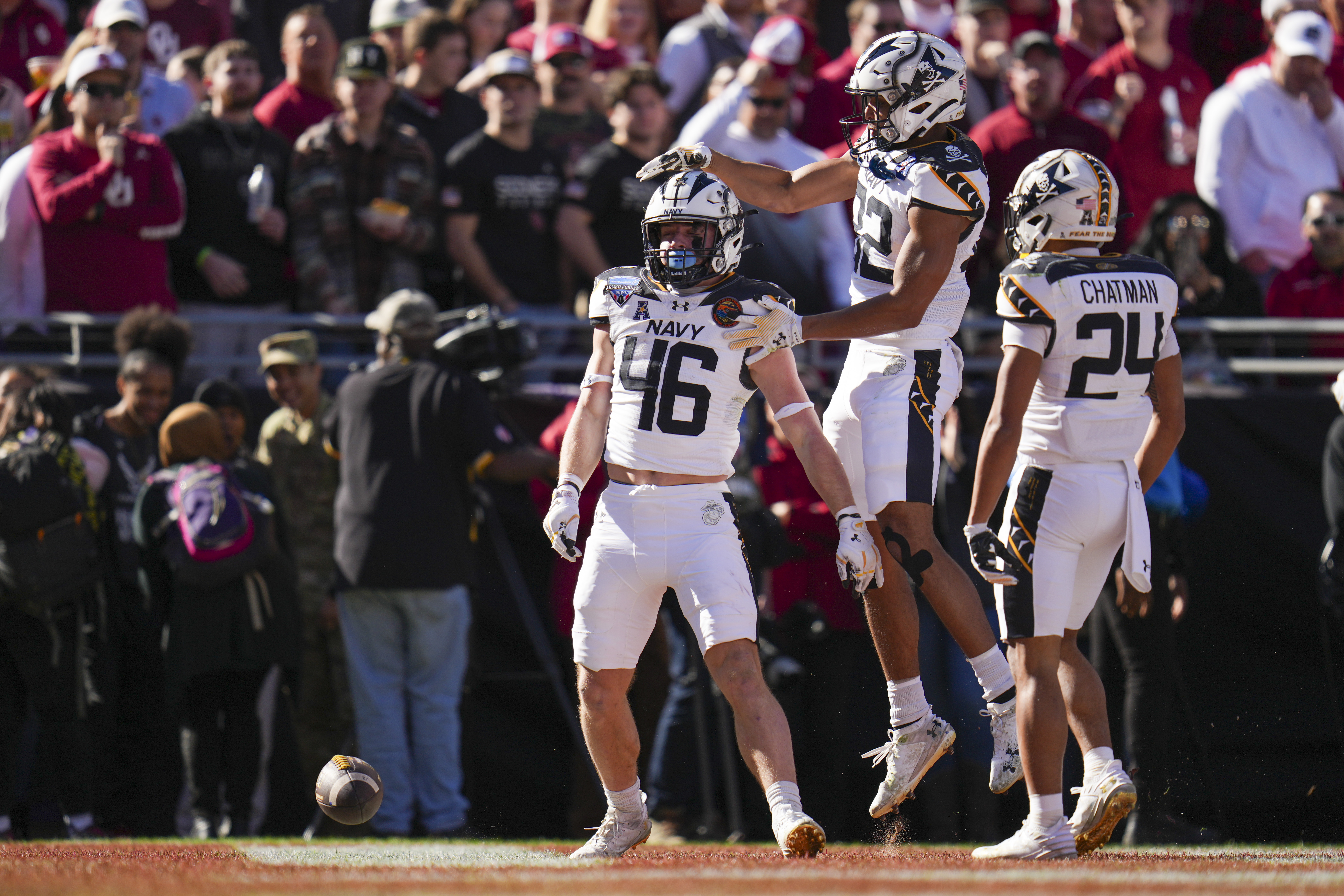 Navy fullback Alex Tecza, (46) celebrates his touchdown run with running backs Eli Heidenreich (22) and Brandon Chatman (24) during the first half of the Armed Forces Bowl NCAA college football game against Oklahoma, Friday, Dec. 27, 2024, in Fort Worth, Texas.