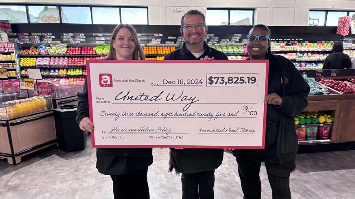 A trio from Southwest Virginia holds a mock check representing the $73,000 and more raised by people in Utah and donated to assist with Hurricane Helene relief.