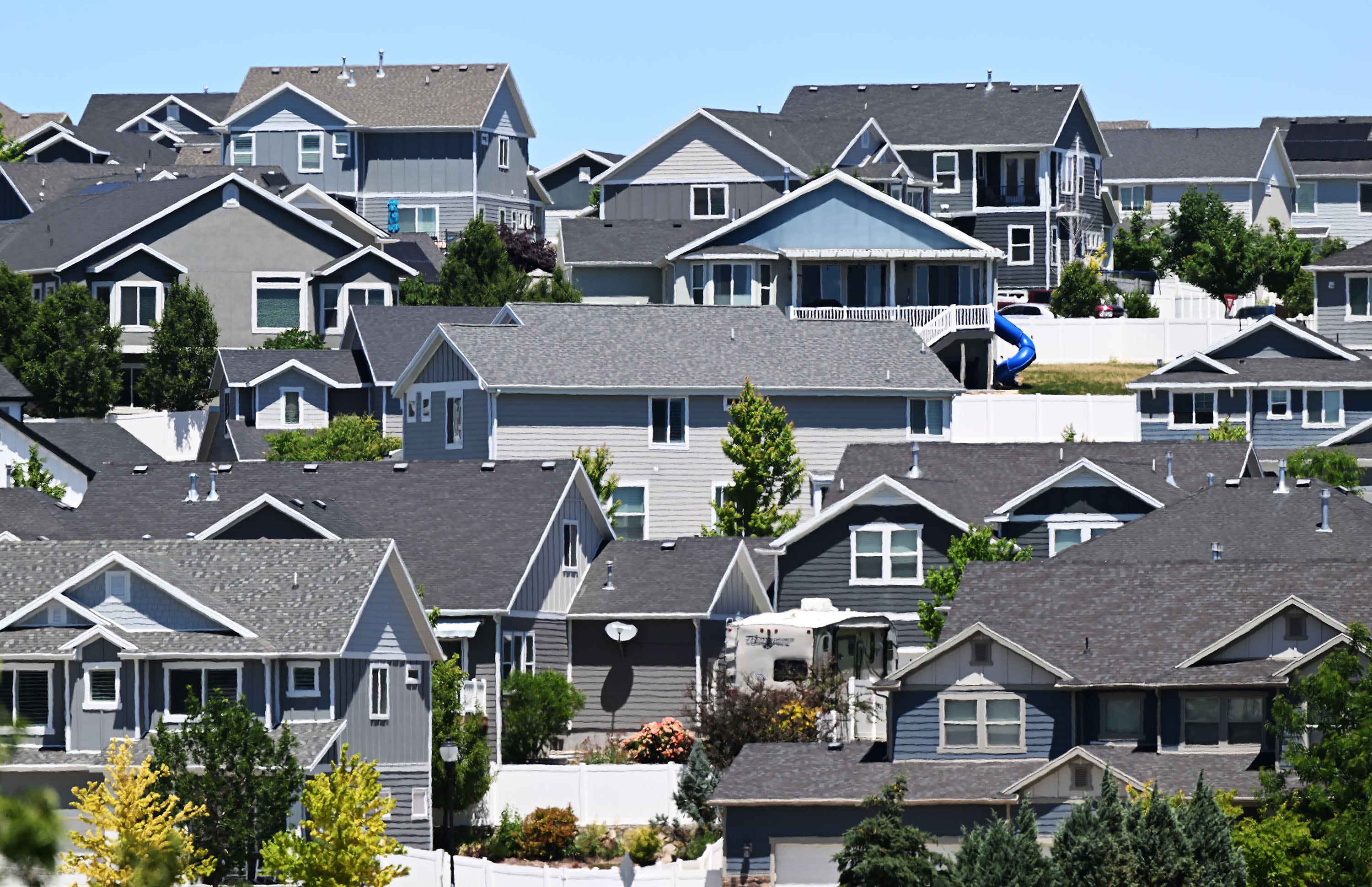 Homes and "For Sale" signs are pictured in the Salt Lake Valley on June 18.