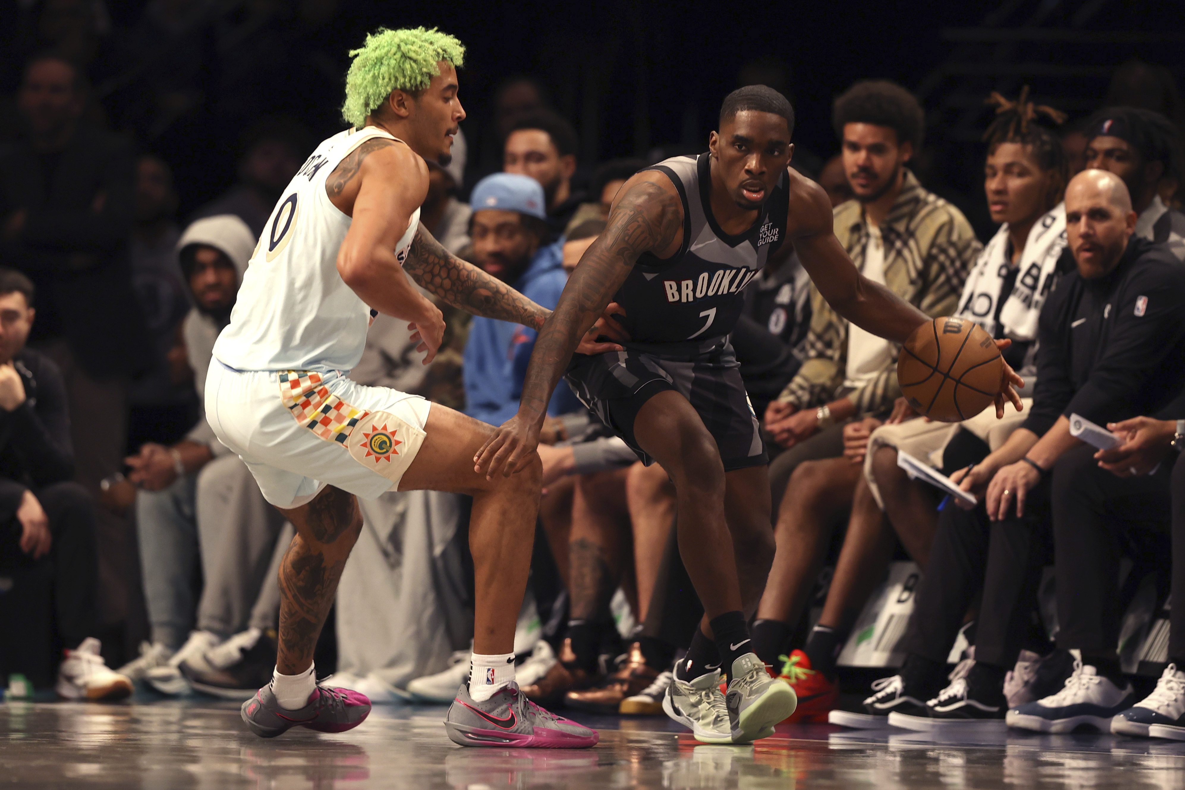 Brooklyn Nets' Shake Milton, right, dribbles the ball against San Antonio Spurs' Jeremy Sochan, left, during the second half of an NBA basketball game Friday, Dec. 27, 2024, in New York.