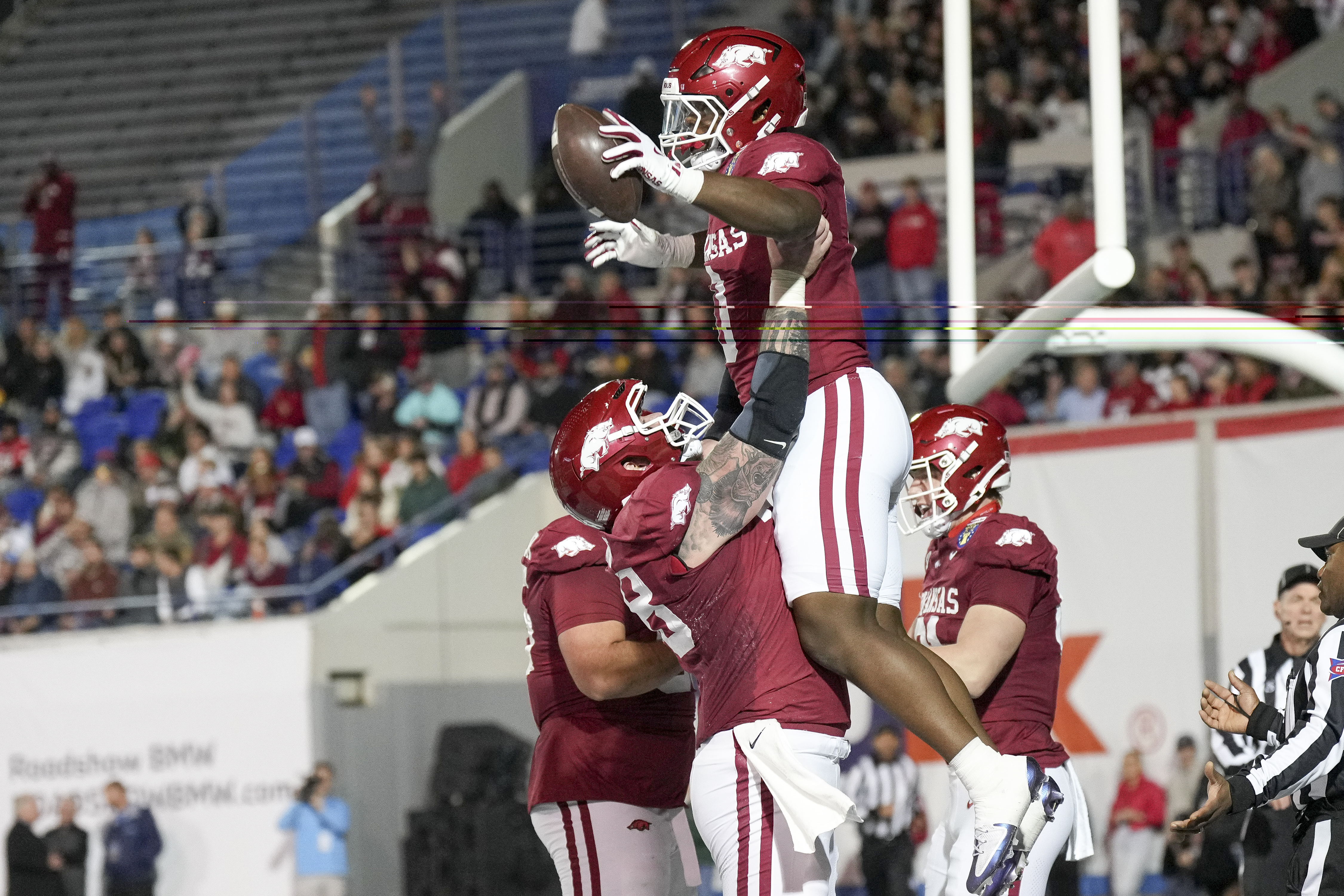 Arkansas running back Braylen Russell, top, celebrates his touchdown with a teammate during the first half of the Liberty Bowl NCAA college football game against Texas Tech, Friday, Dec. 27, 2024, in Memphis, Tenn. 