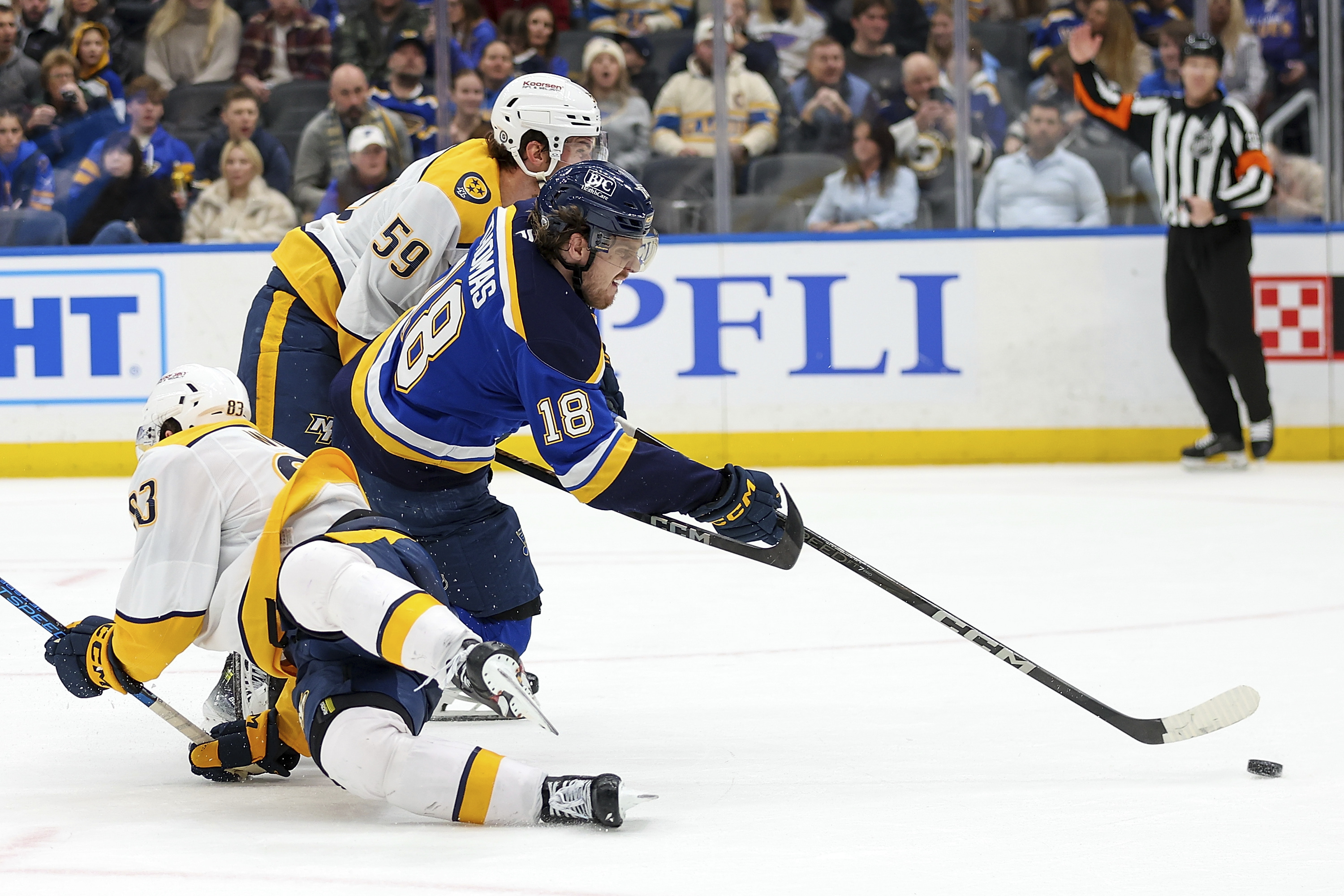 St. Louis Blues' Robert Thomas (18) shoots on goal while under pressure from Nashville Predators' Adam Wilsby (83) and Roman Josi (59) during the second period of an NHL hockey game Friday, Dec. 27, 2024, in St. Louis.