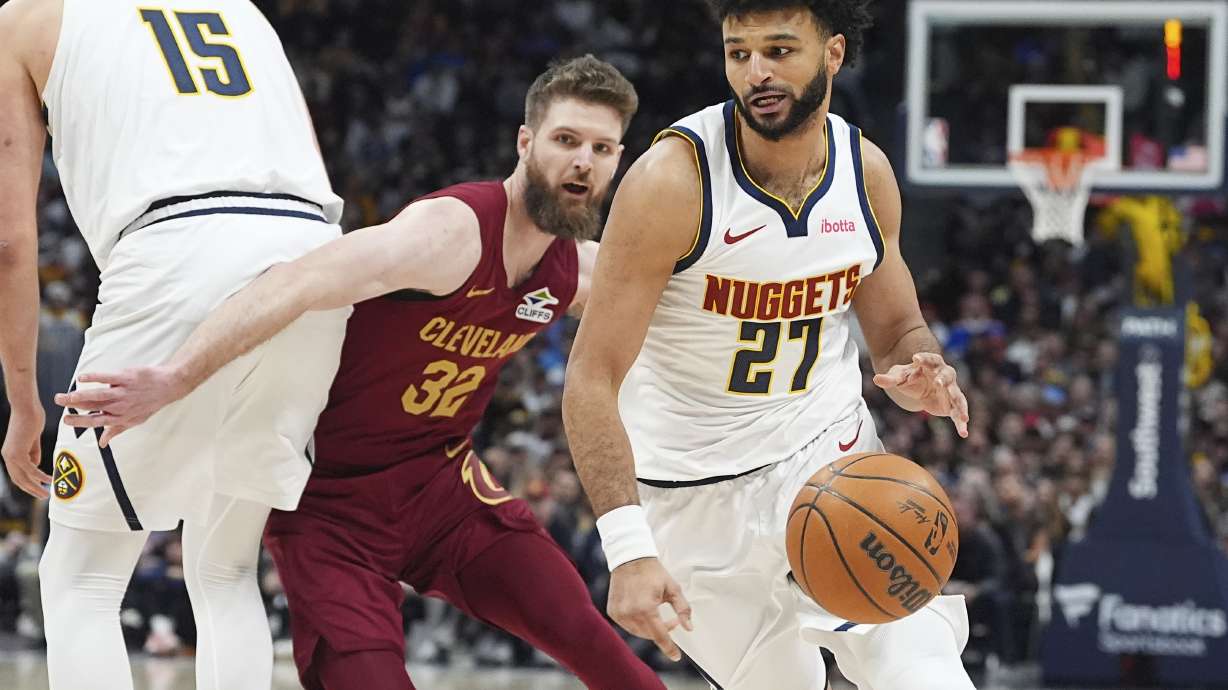 Denver Nuggets guard Jamal Murray, front, drives past Cleveland Cavaliers forward Dean Wade in the first half of an NBA basketball game Friday, Dec. 27, 2024, in Denver.
