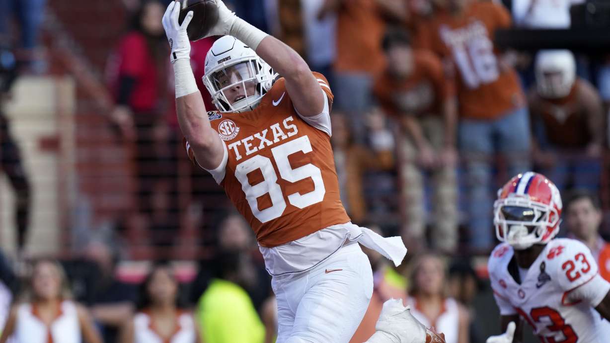 Texas tight end Gunnar Helm (85) catches a 19-yard touchdown pass ahead of Clemson cornerback Ashton Hampton (23) during the first half in the first round of the College Football Playoff, Saturday, Dec. 21, 2024, in Austin, Texas.