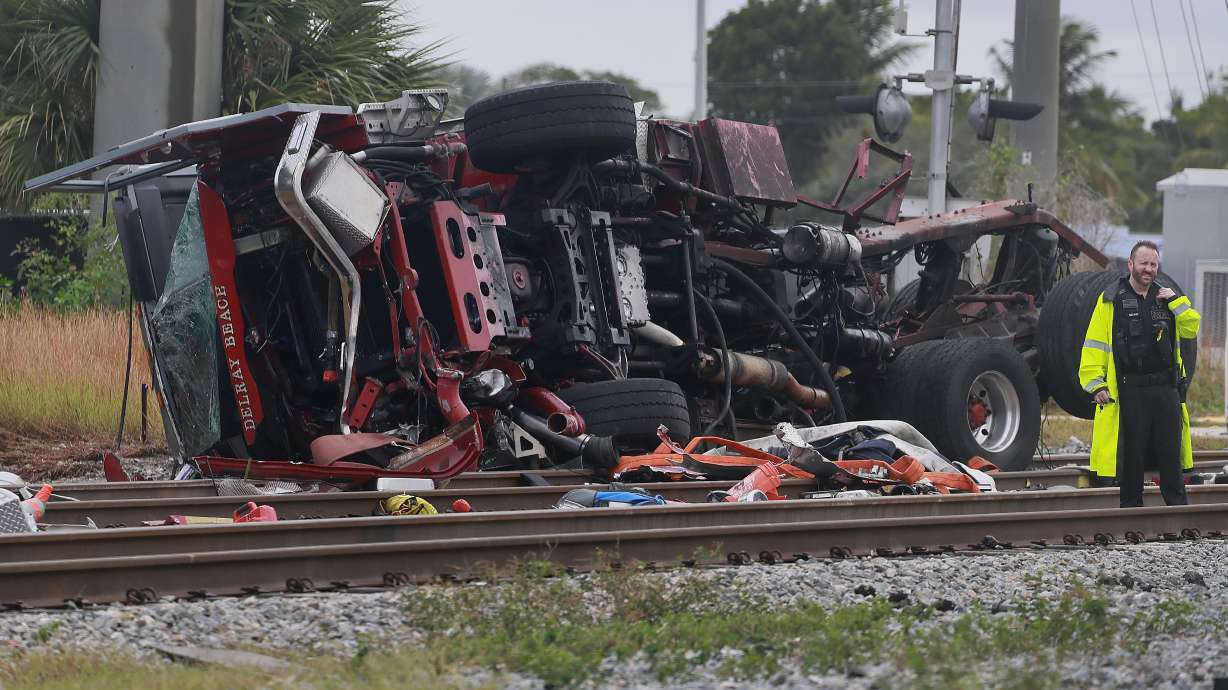 A damaged fire truck is on its side after colliding with a train in downtown Delray Beach, Fla., on Saturday.