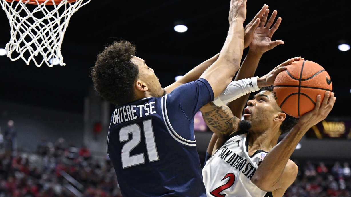 San Diego State guard Nick Boyd (2) tries to shoot over Utah State center Aubin Gateretse (21) during the first half of an NCAA college basketball game Saturday, Dec. 28, 2024, in San Diego.