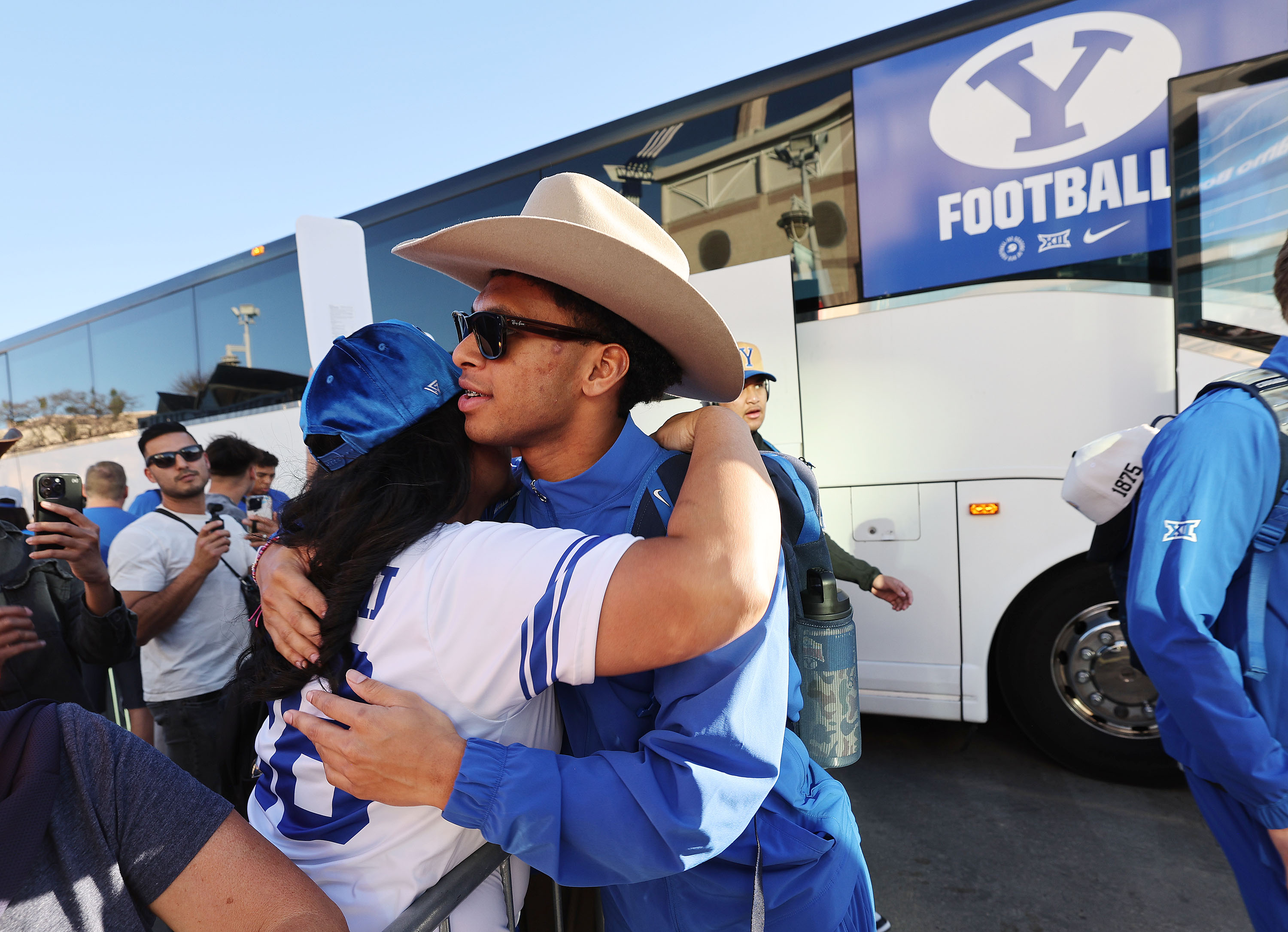 BYU running back Jovesa Damuni (28) gets a hug as the team arrives at the Valero Alamo Bowl in San Antonio on Saturday, Dec. 28, 2024.