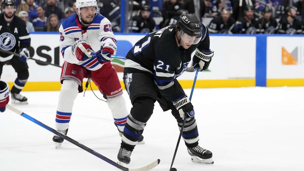 Tampa Bay Lightning center Brayden Point (21) controls the puck in front of New York Rangers defenseman Ryan Lindgren (55) during the second period of an NHL hockey game Saturday, Dec. 28, 2024, in Tampa, Fla.