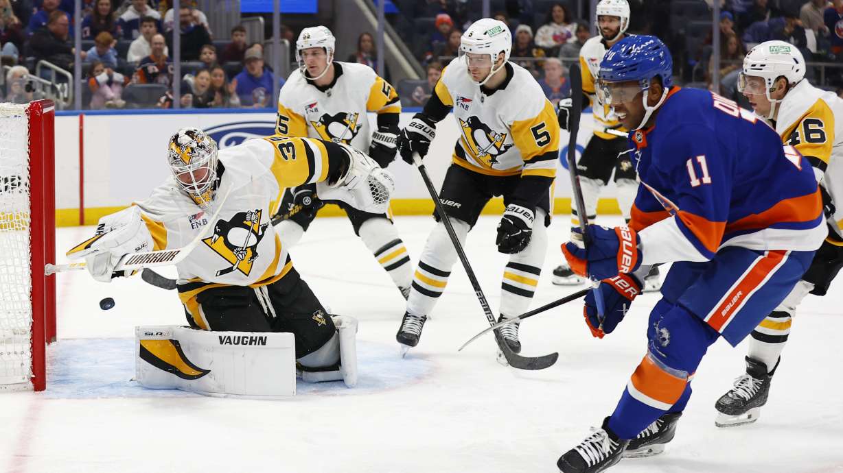 New York Islanders left wing Anthony Duclair (11) scores against Pittsburgh Penguins goaltender Tristan Jarry, left, during the second period of an NHL hockey game, Saturday, Dec. 28, 2024, in New York.