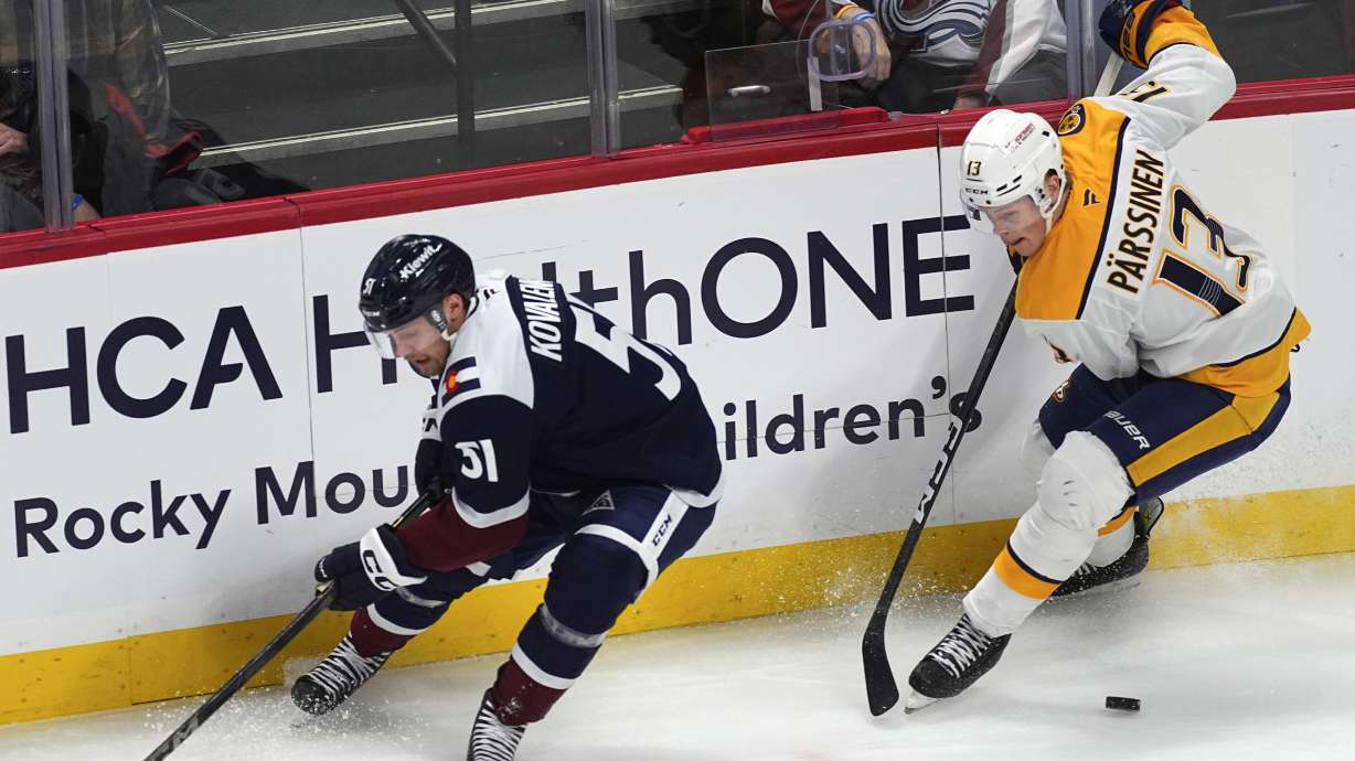 FILE - Nashville Predators center Juuso Parssinen, right, collects the puck against Colorado Avalanche right wing Nikolai Kovalenko in the first period of an NHL hockey game on Nov. 11, 2024, in Denver.