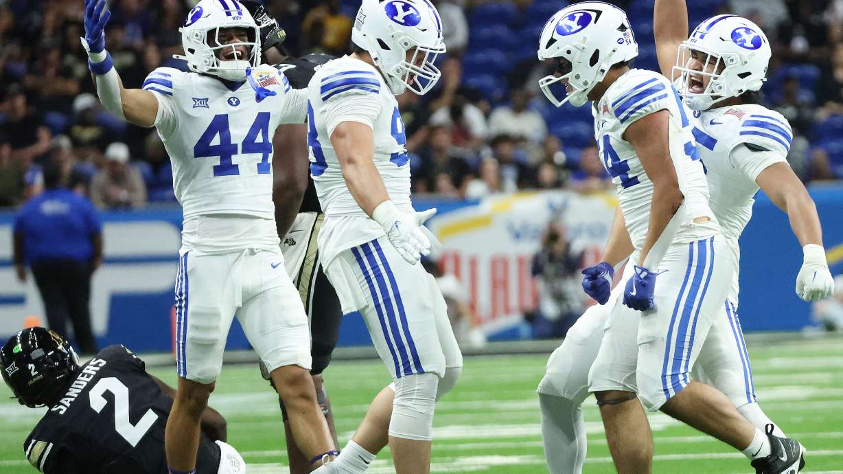 BYU's defense celebrates sacking Colorado Buffaloes quarterback Shedeur Sanders (2) during the Valero Alamo Bowl in San Antonio on Saturday, Dec. 28, 2024. BYU won 36-14.