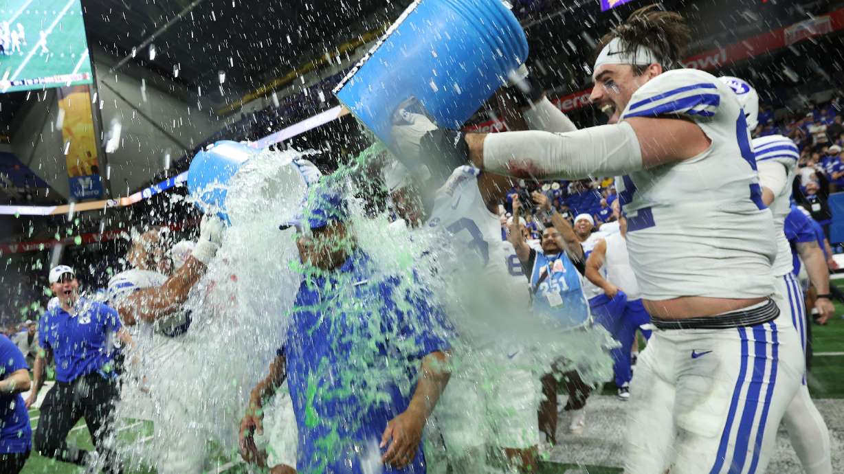 Brigham Young defensive end Tyler Batty (92) douses BYU head coach Kalani Sitake during the Valero Alamo Bowl in San Antonio on Saturday, Dec. 28, 2024. BYU won 36-14.