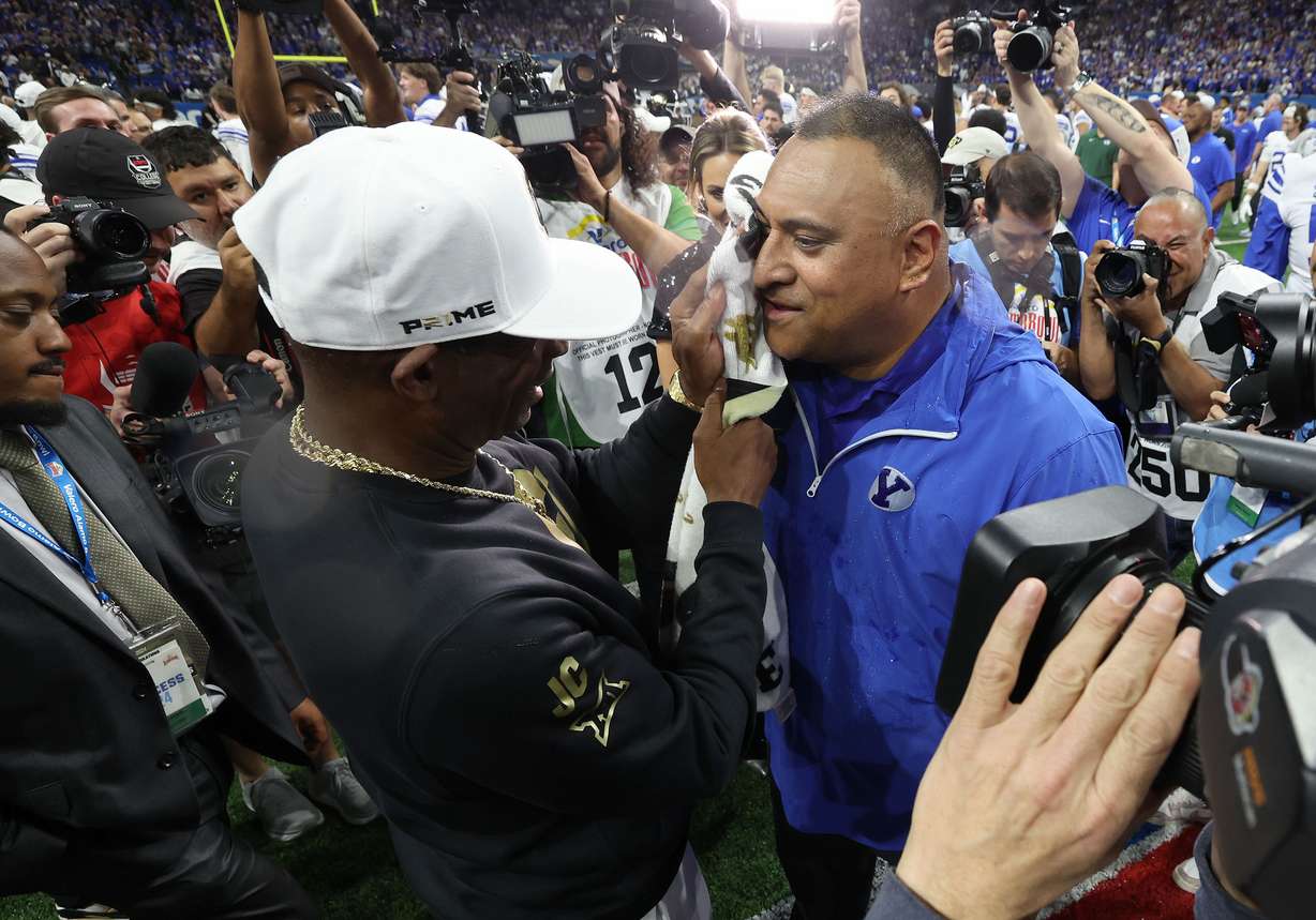 Colorado Buffaloes head coach Deion Sanders wipes gatorade off of Brigham Young Cougars head coach Kalani Sitake after the Valero Alamo Bowl in San Antonio on Saturday, Dec. 28, 2024. BYU won 36-14.