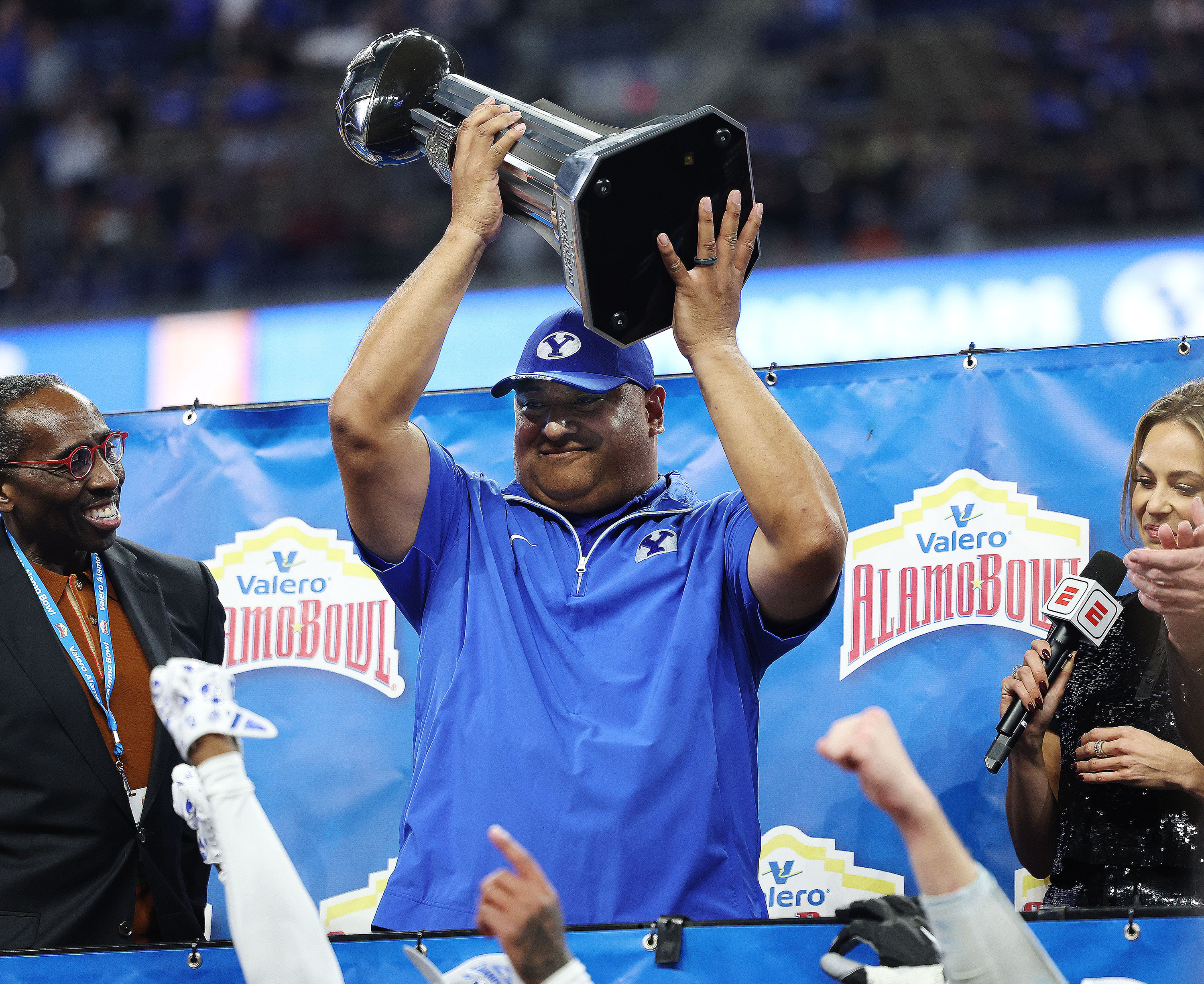 Brigham Young head coach Kalani Sitake  holds the trophy during the Valero Alamo Bowl in San Antonio on Saturday, Dec. 28, 2024. BYU won 36-14.