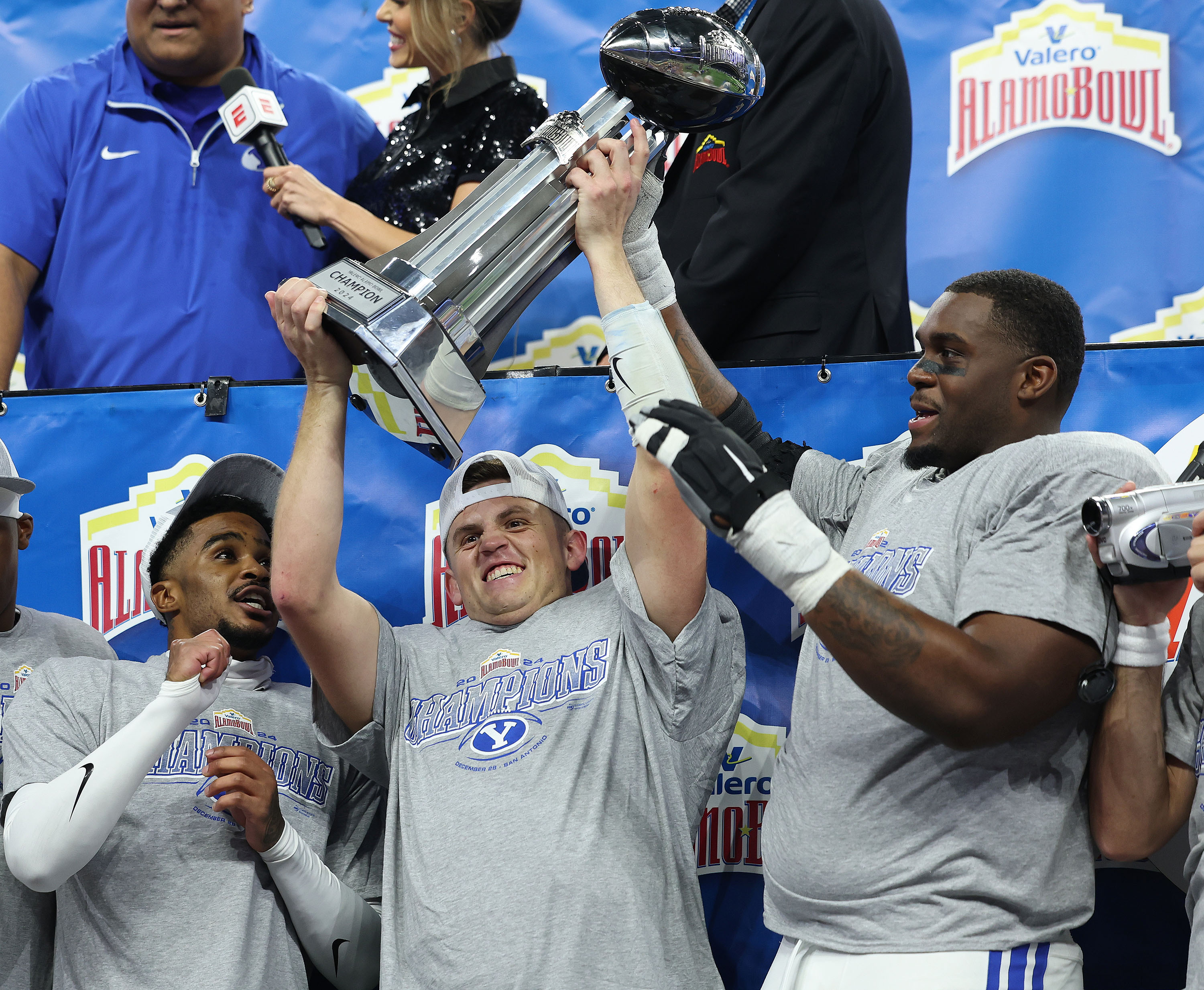 Brigham Young quarterback Jake Retzlaff (12) hoists the trophy after beating the Colorado Buffaloes during the Valero Alamo Bowl in San Antonio on Saturday, Dec. 28, 2024. BYU won 36-14.