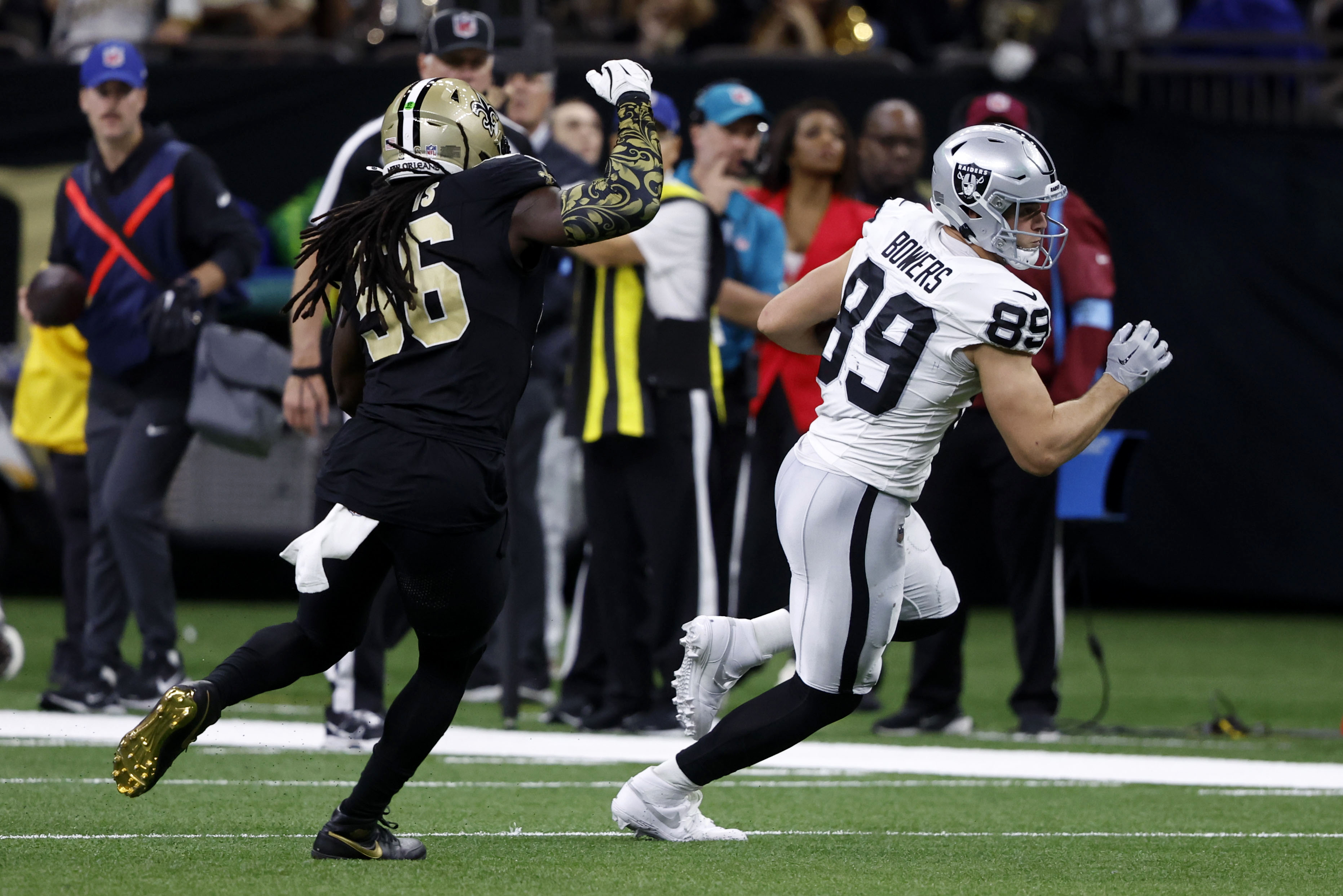 Las Vegas Raiders tight end Brock Bowers (89) runs from New Orleans Saints linebacker Demario Davis (56) after catching a pass during the first half of an NFL football game, Sunday, Dec. 29, 2024, in New Orleans.