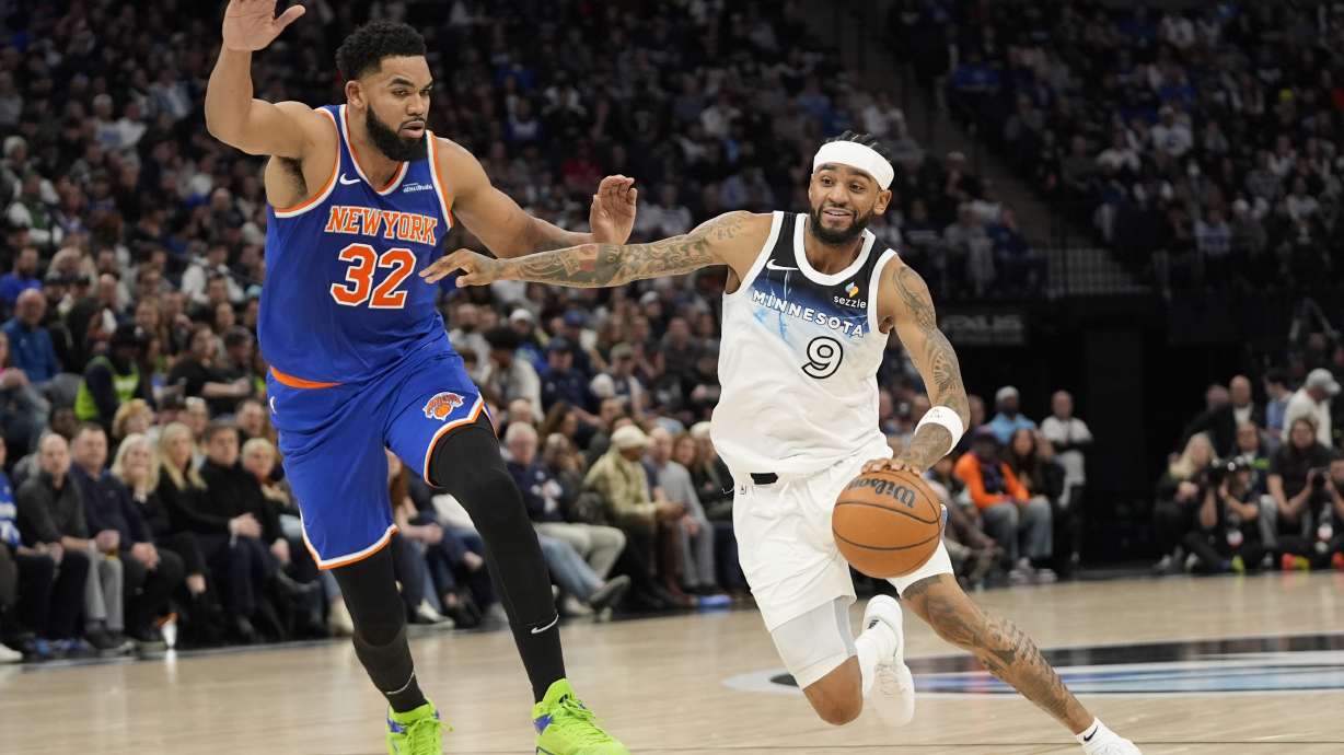Minnesota Timberwolves guard Nickeil Alexander-Walker (9) works toward the basket as New York Knicks center Karl-Anthony Towns (32) defends during the first half of an NBA basketball game, Thursday, Dec. 19, 2024, in Minneapolis.
