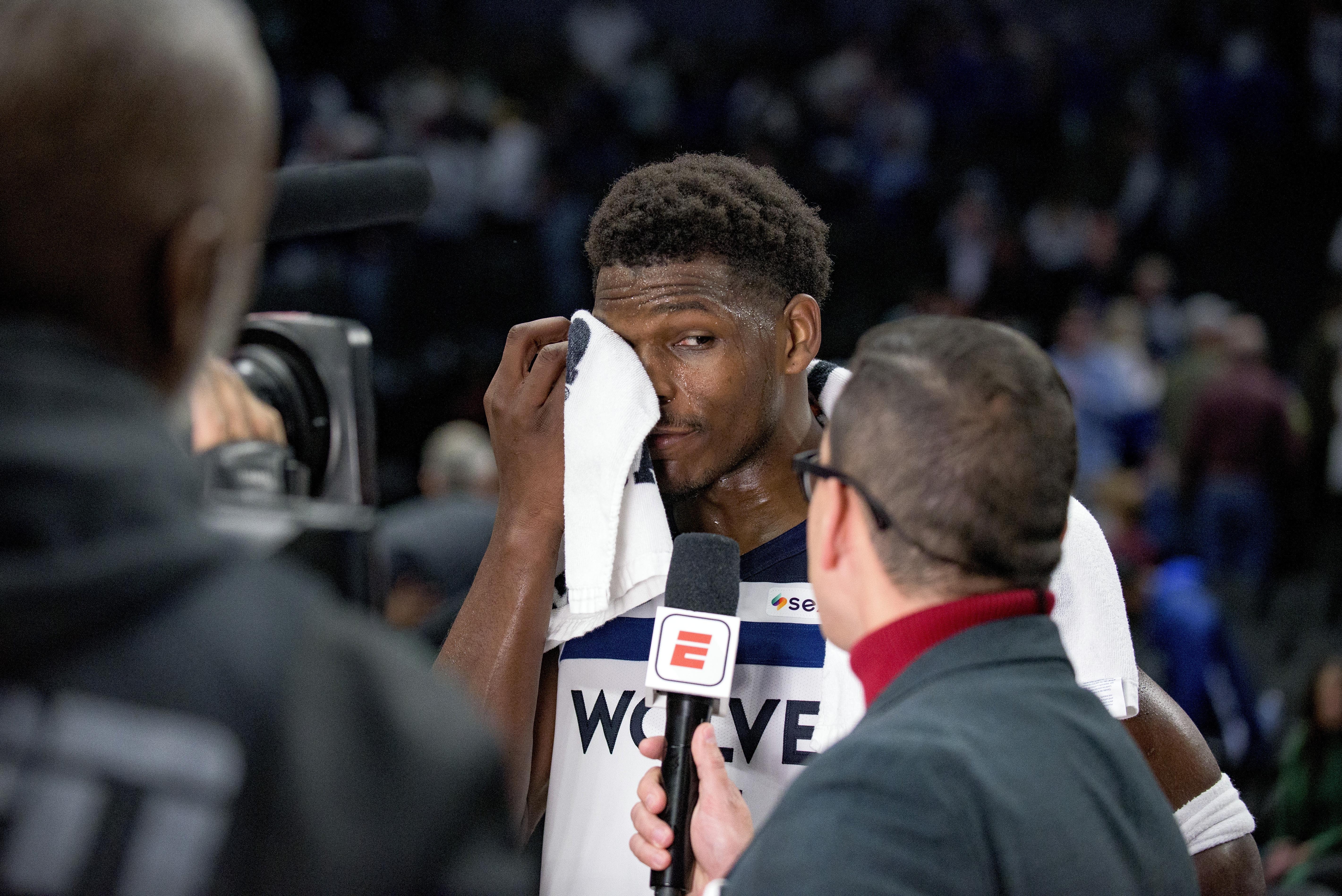 Minnesota Timberwolves guard Anthony Edwards wipes his face with a towel while listening to a question from a reporter following an NBA basketball game against the Dallas Mavericks on Wednesday, Dec. 25, 2024, in Dallas.