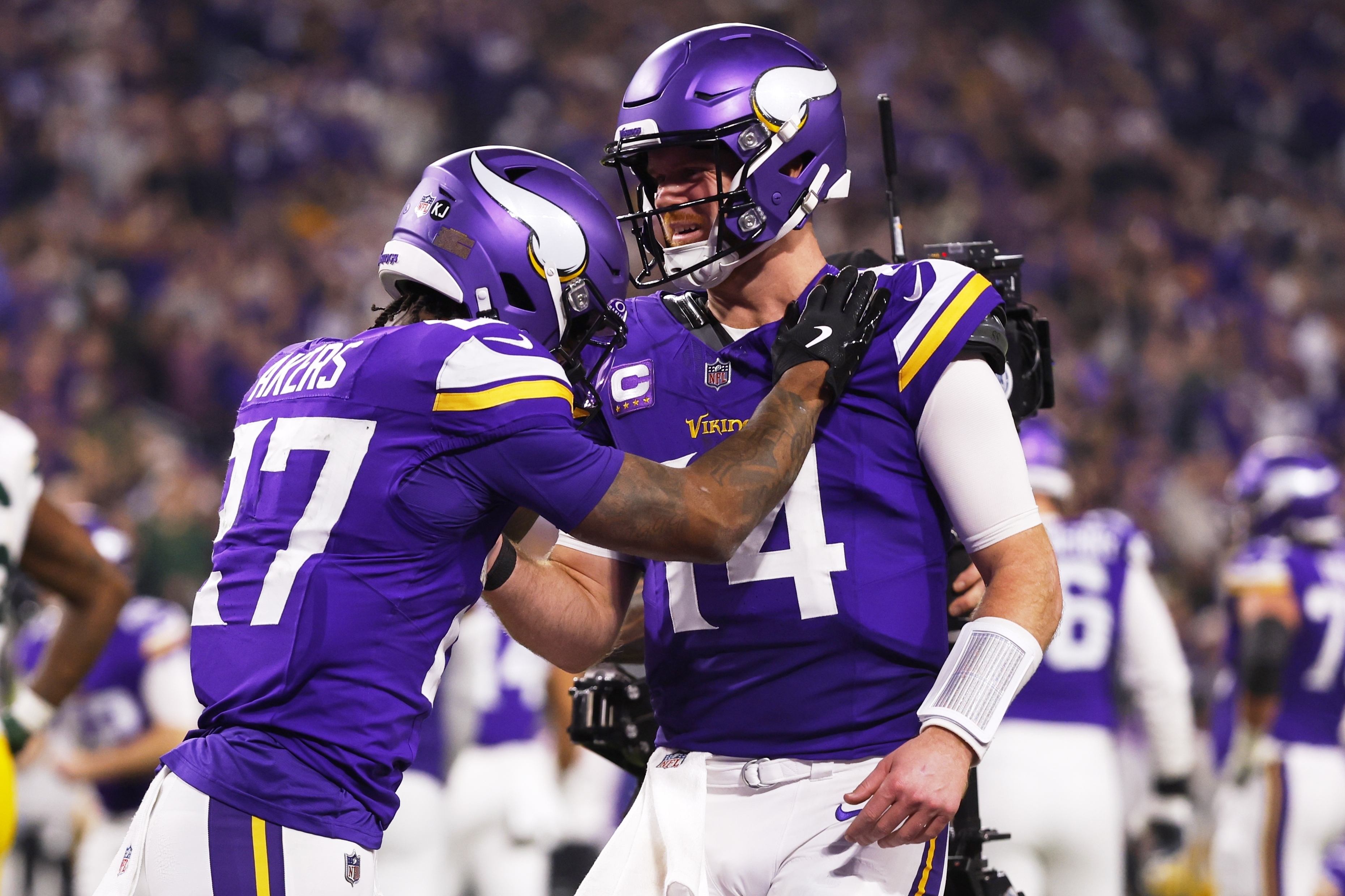 Minnesota Vikings' Sam Darnold congratulates Cam Akers on a touchdown catch during the second half of an NFL football game against the Green Bay Packers Sunday, Dec. 29, 2024, in Minneapolis.
