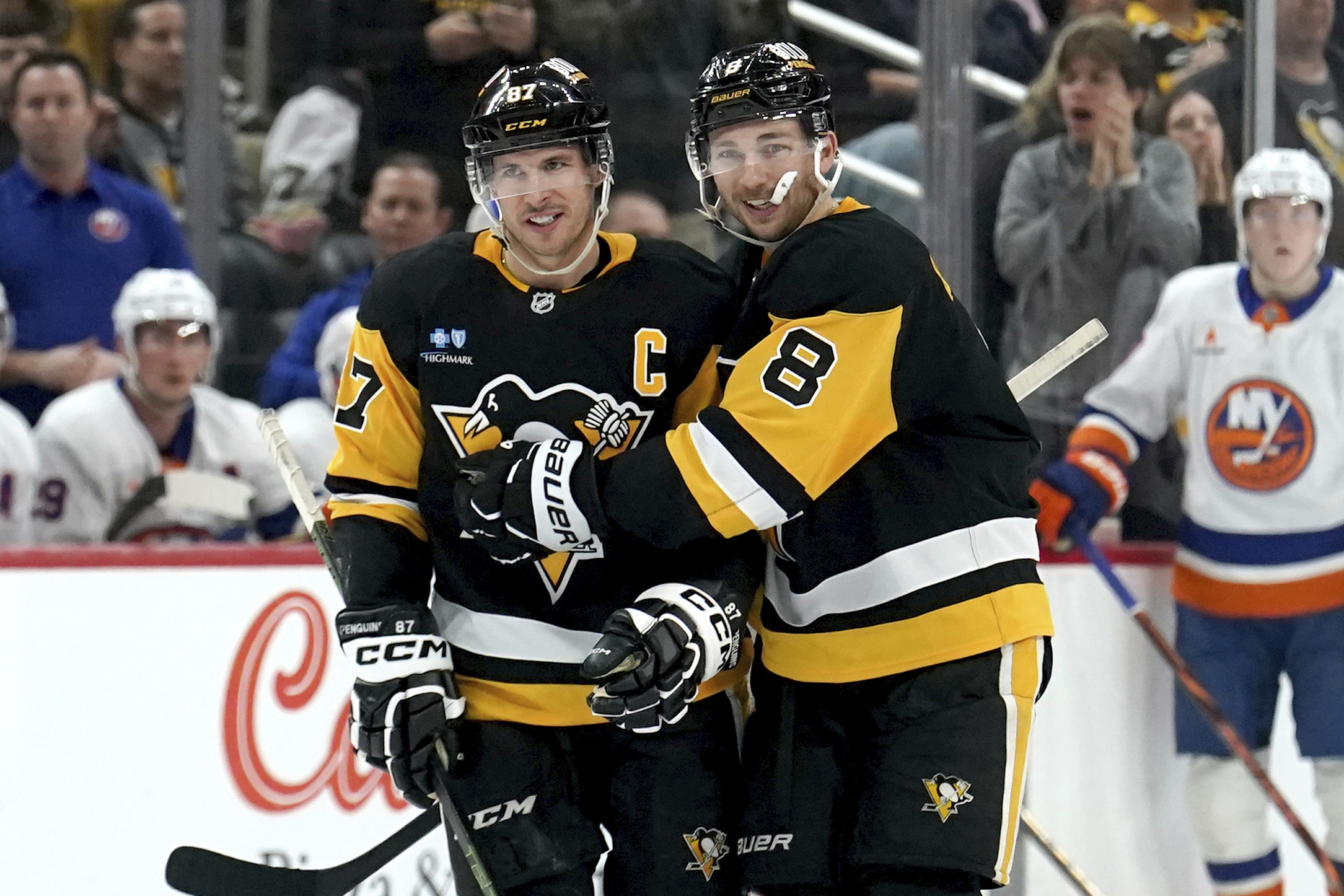 Pittsburgh Penguins' Michael Bunting (8) celebrates with Sidney Crosby (87) after scoring during the second period of an NHL hockey game against the New York Islanders, Sunday, Dec. 29, 2024, in Pittsburgh. 