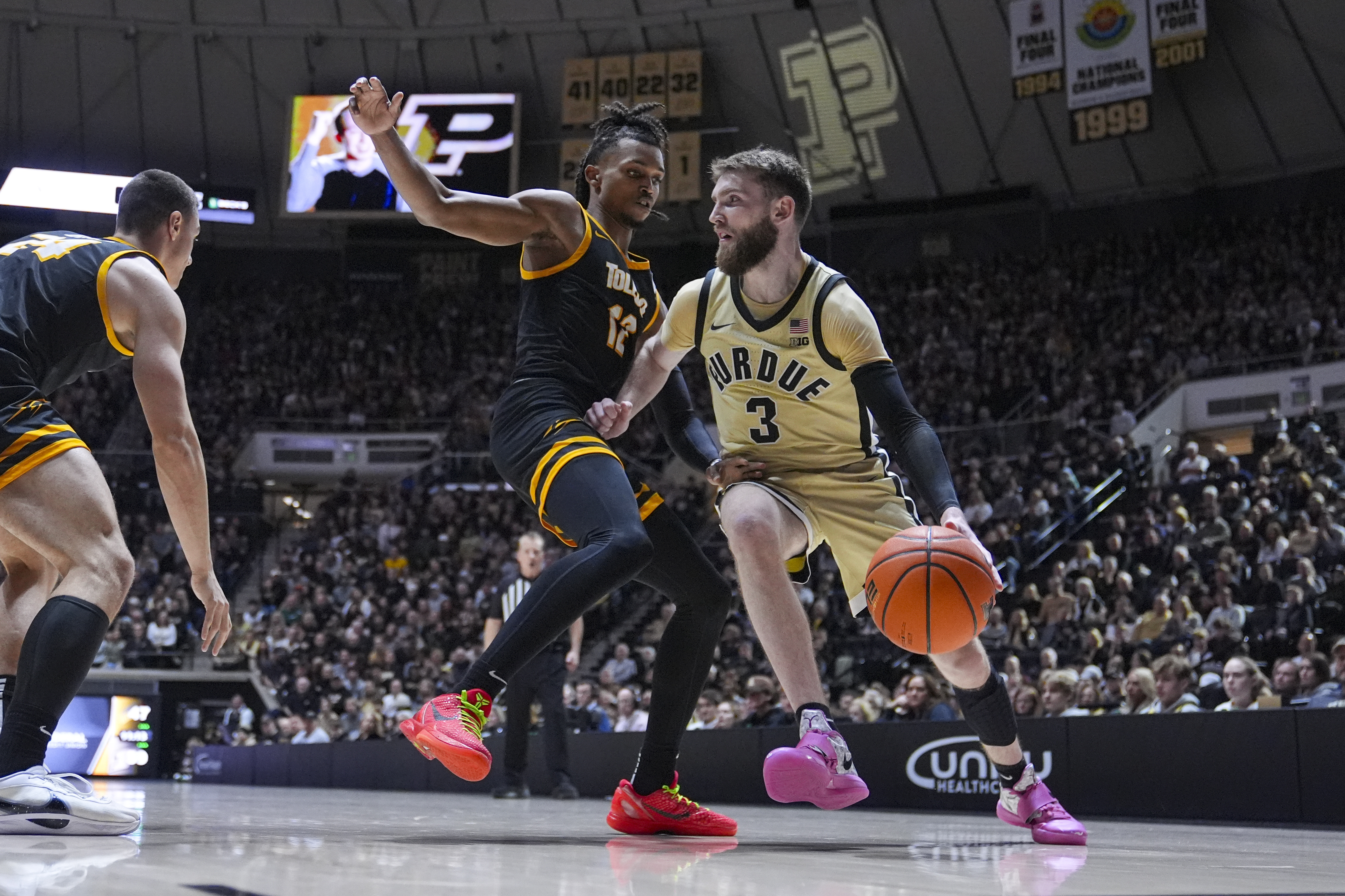 Purdue guard Braden Smith (3) under past Toledo guard Seth Hubbard (12) during the second half of an NCAA college basketball game in West Lafayette, Ind., Sunday, Dec. 29, 2024. 