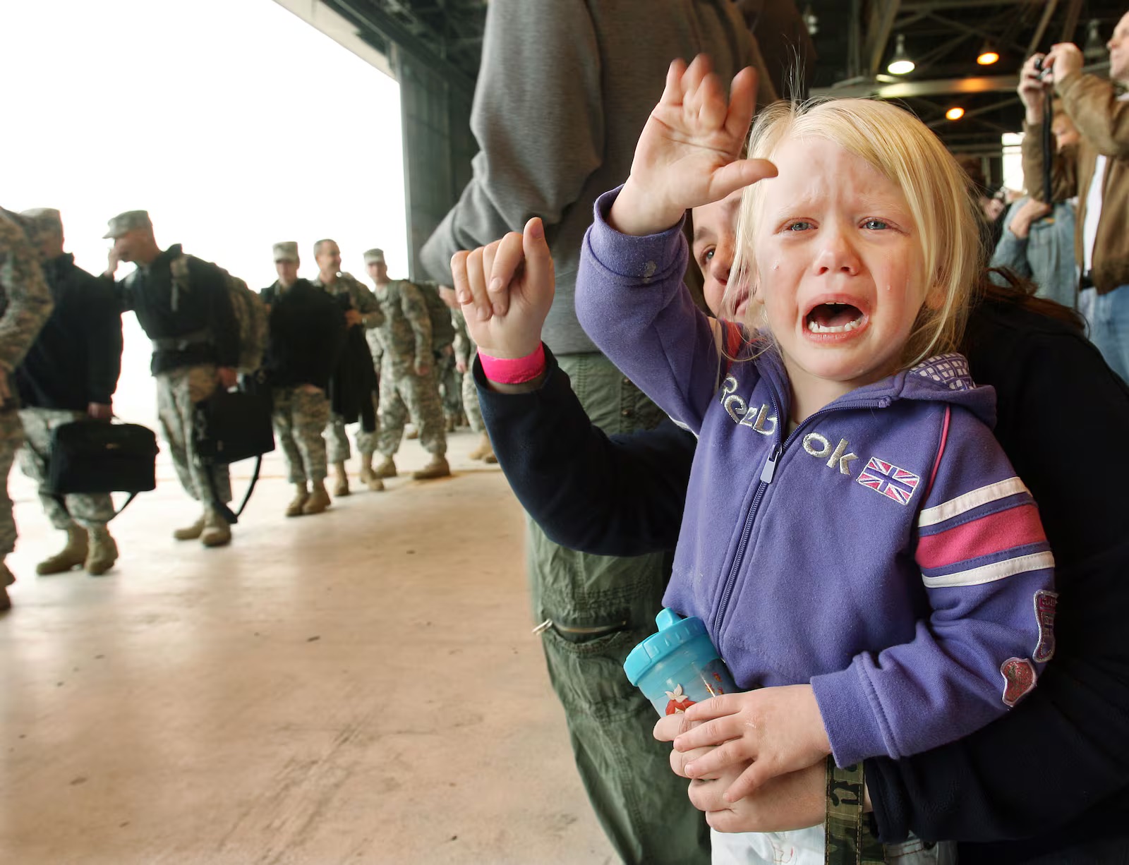 Three-year-old Mia Peterson cries with her mother Rebecca as she waves goodbye to her dad as he and other members of the 2nd Battalion, 211th Army Aviation Regiment depart for a 12-month deployment on Feb. 20, 2008, in Salt Lake City.