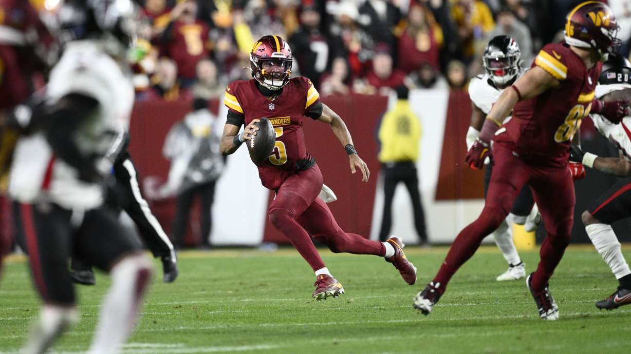 Washington Commanders quarterback Jayden Daniels (5) carries on a keeper during the second half of an NFL football game against the Atlanta Falcons, Sunday, Dec. 29, 2024, in Landover, Md.