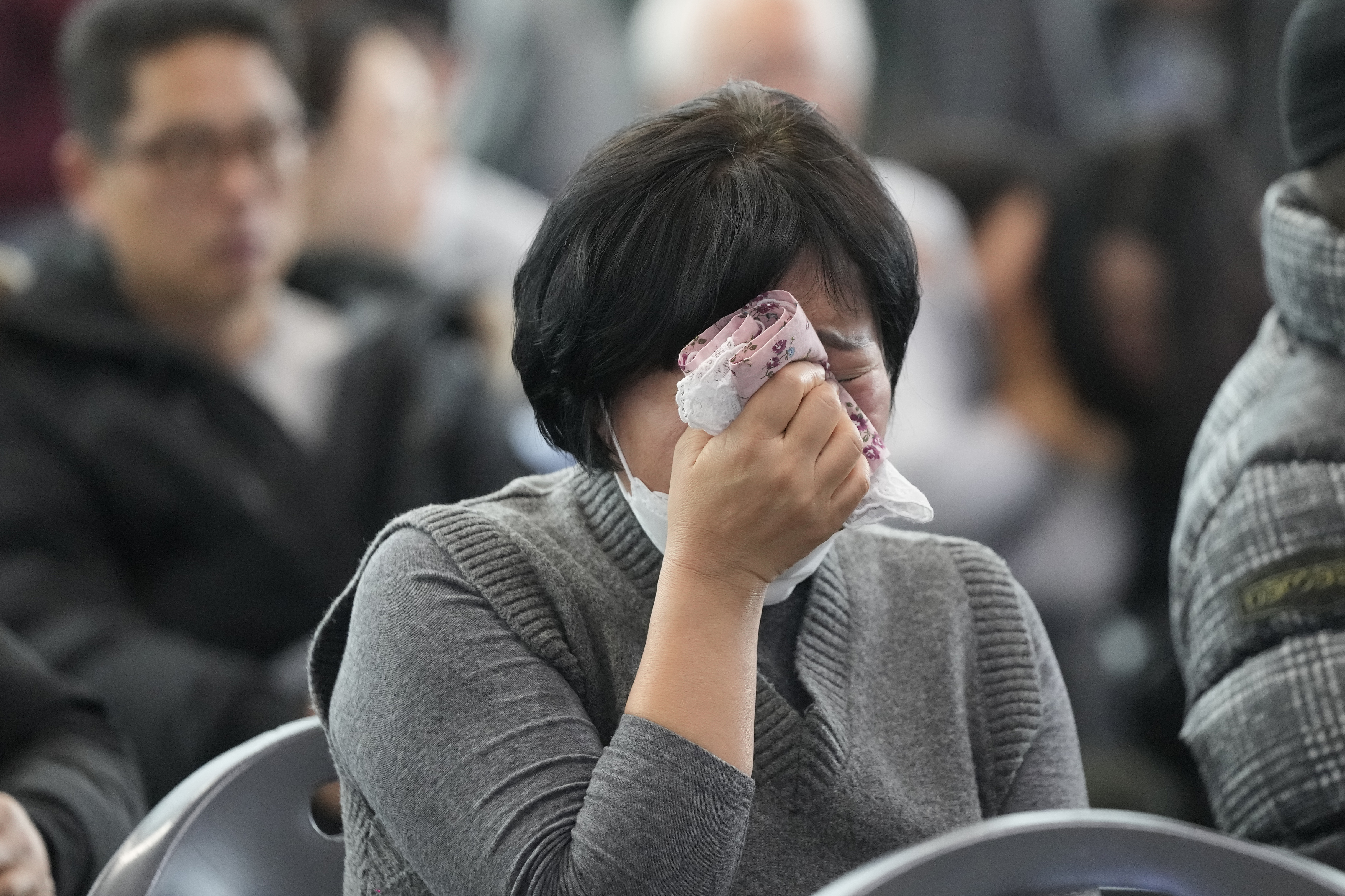 A relative of a passenger of a plane that burst into flames reacts at a temporary shelter at Muan International Airport in Muan, South Korea, Monday.