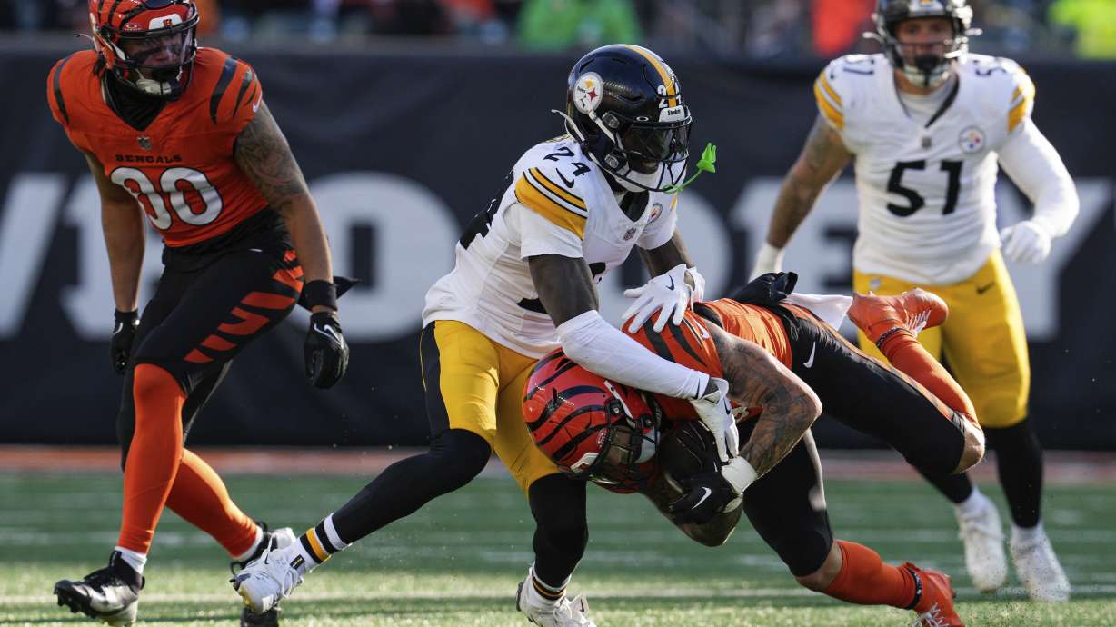 Pittsburgh Steelers cornerback Joey Porter Jr. (24) tackles Cincinnati Bengals running back Chase Brown, center bottom, during the first half of an NFL football game Sunday, Dec. 1, 2024, in Cincinnati.