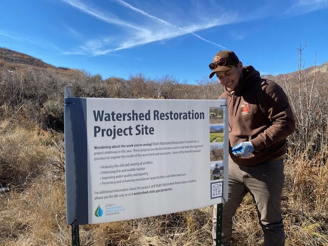 A member of the Utah Department of Natural Resources puts up a sign for a Watershed Restoration Initiative project in this undated photo.