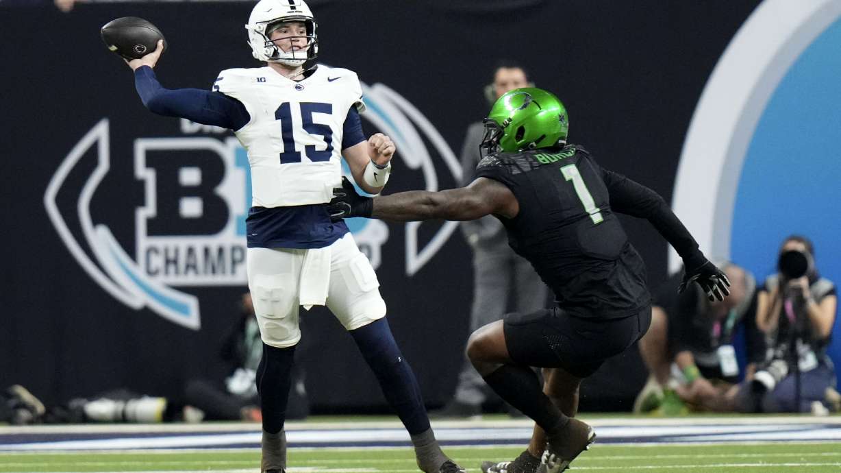 Penn State quarterback Drew Allar (15) throws a pass over Oregon defensive end Jordan Burch (1) during the first half of the Big Ten championship NCAA college football game, Saturday, Dec. 7, 2024, in Indianapolis.
