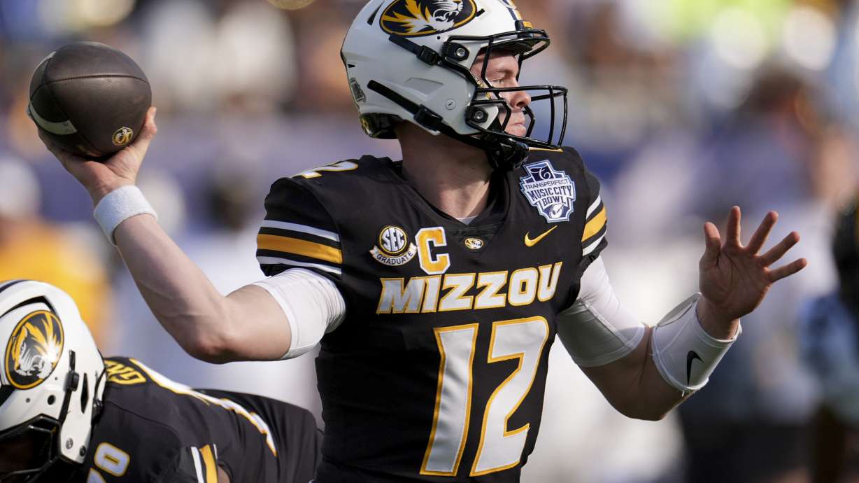 Missouri quarterback Brady Cook (12) looks to throw a pass during the first half of the Music City Bowl NCAA college football game against Iowa, Monday, Dec. 30, 2024, in Nashville, Tenn.